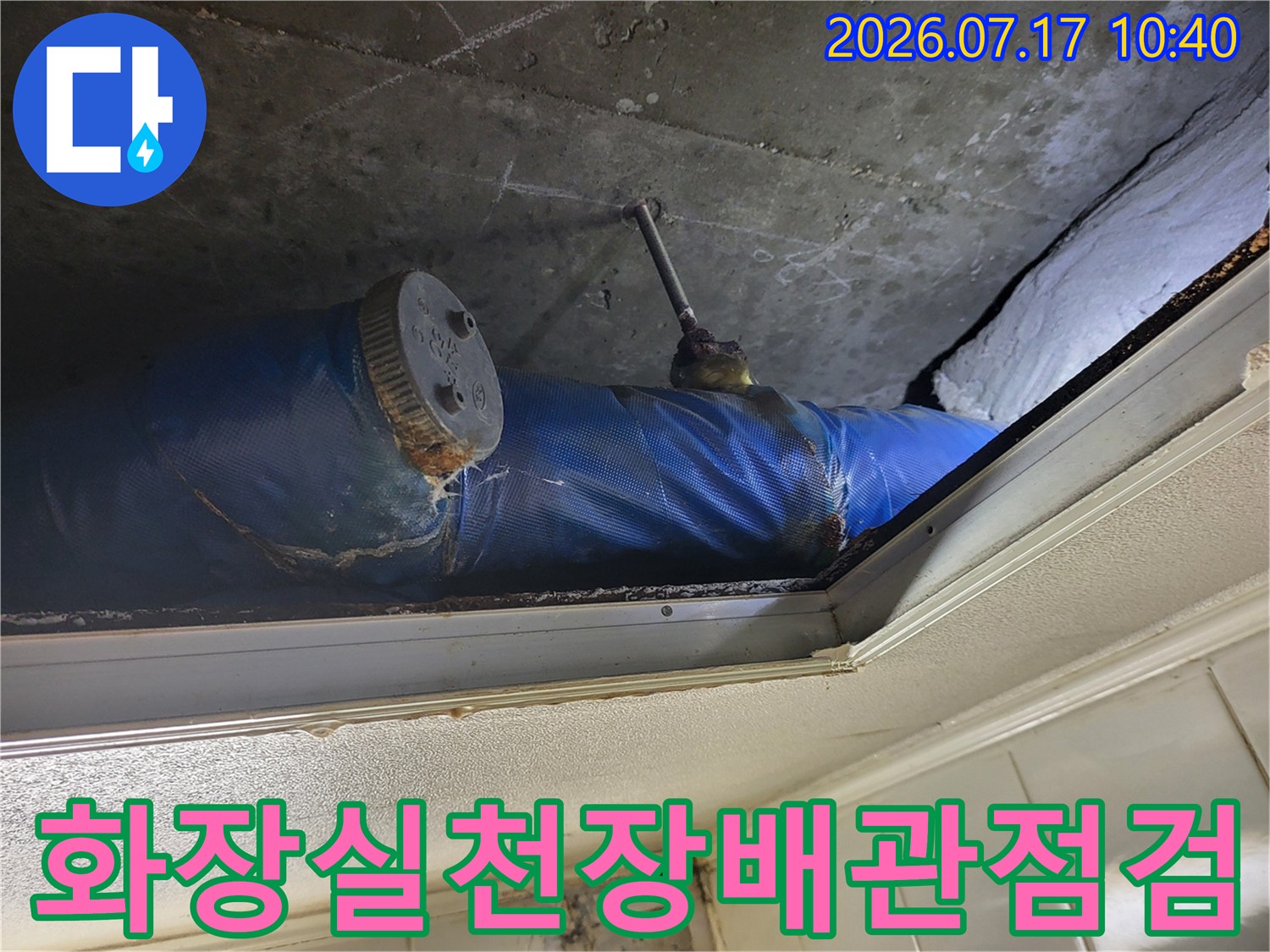 파란색 보온재로 감싸진 배관과 압력 게이지가 설치된 점검구 내부 모습
