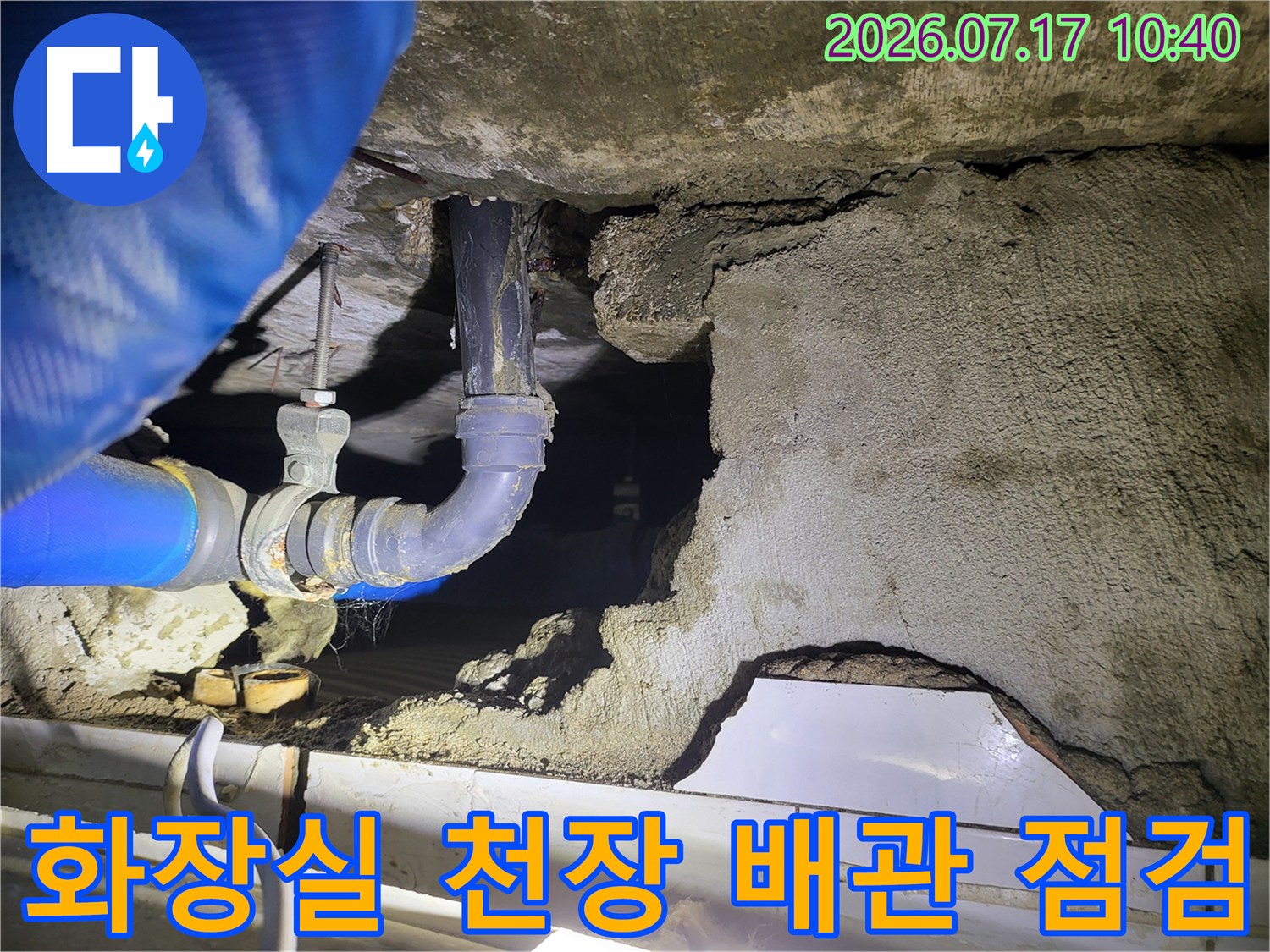 파란색 호스와 압력계가 연결된 화장실 천장 내부 배관 점검 모습
