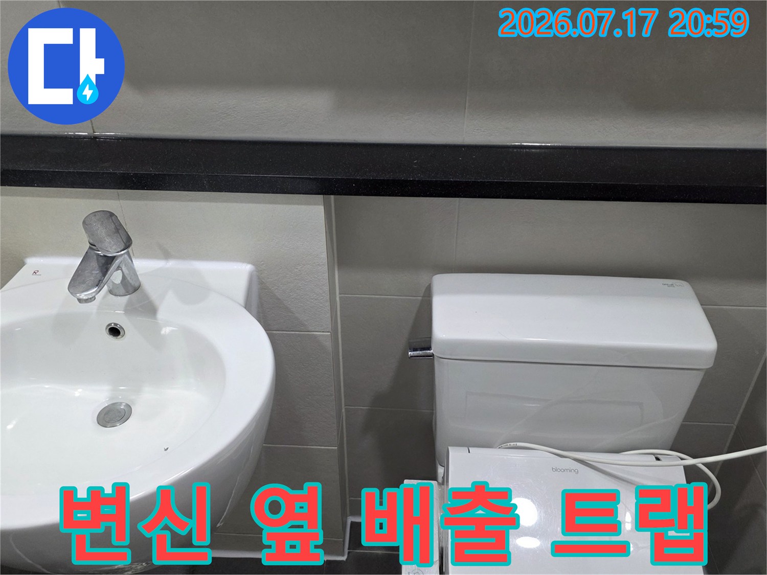 세면대와 변신 사이 공간에 노출된 화장실용 배수관 시스템