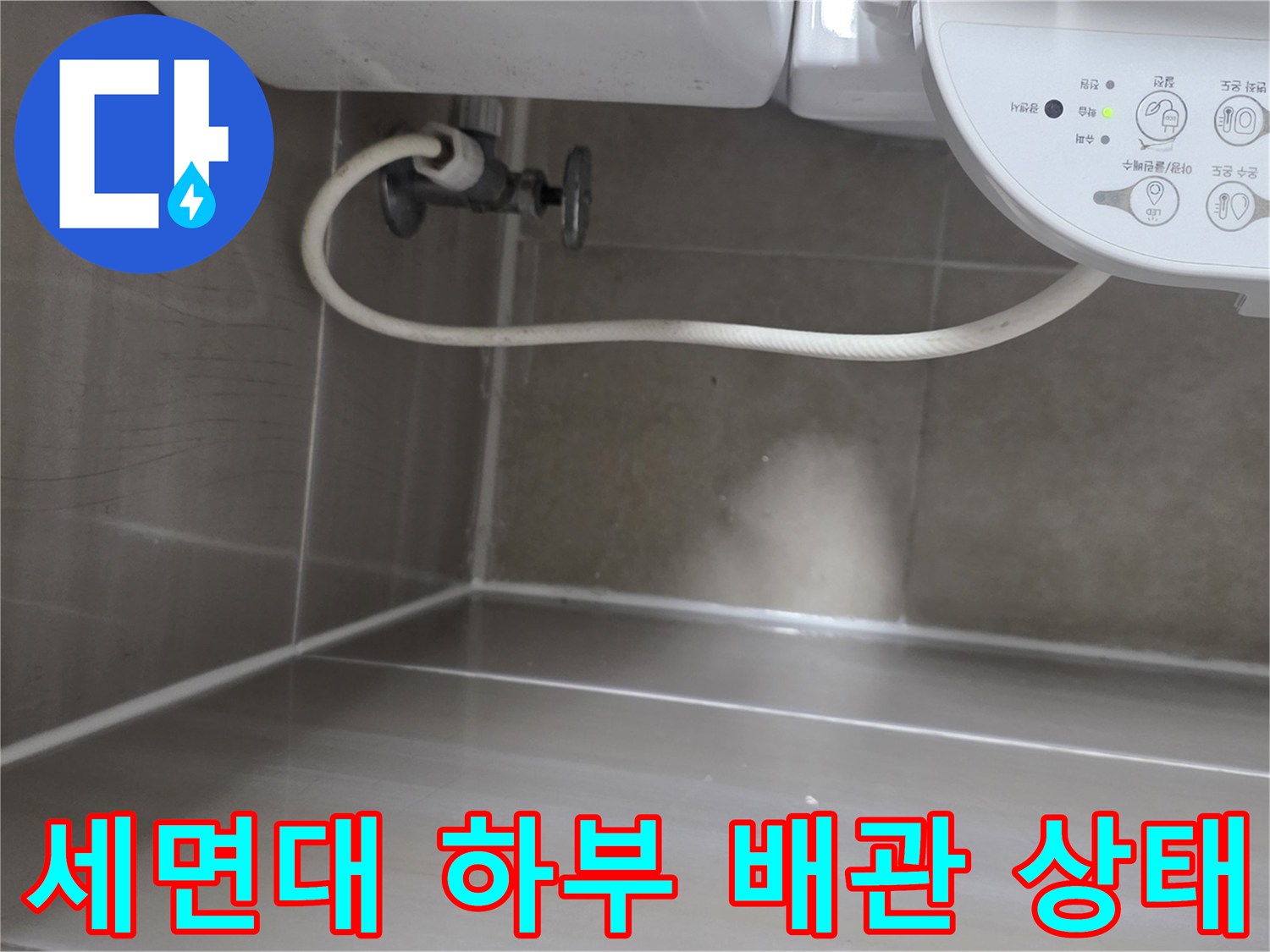 화장실 세면대 아래쪽 배관 연결 부위와 벽면 타일 근접 촬영