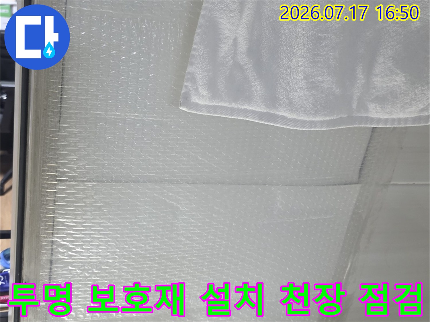 화장실-천장-타일-위에-설치된-투명한-비닐-보호막과-점검용-수건
