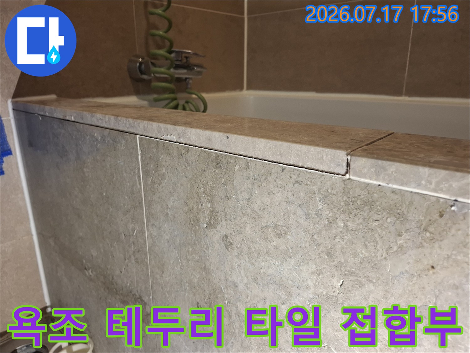 욕조 주변을 마감한-베이지색 석재 타일의 이음새가 벌어진 근접 사진