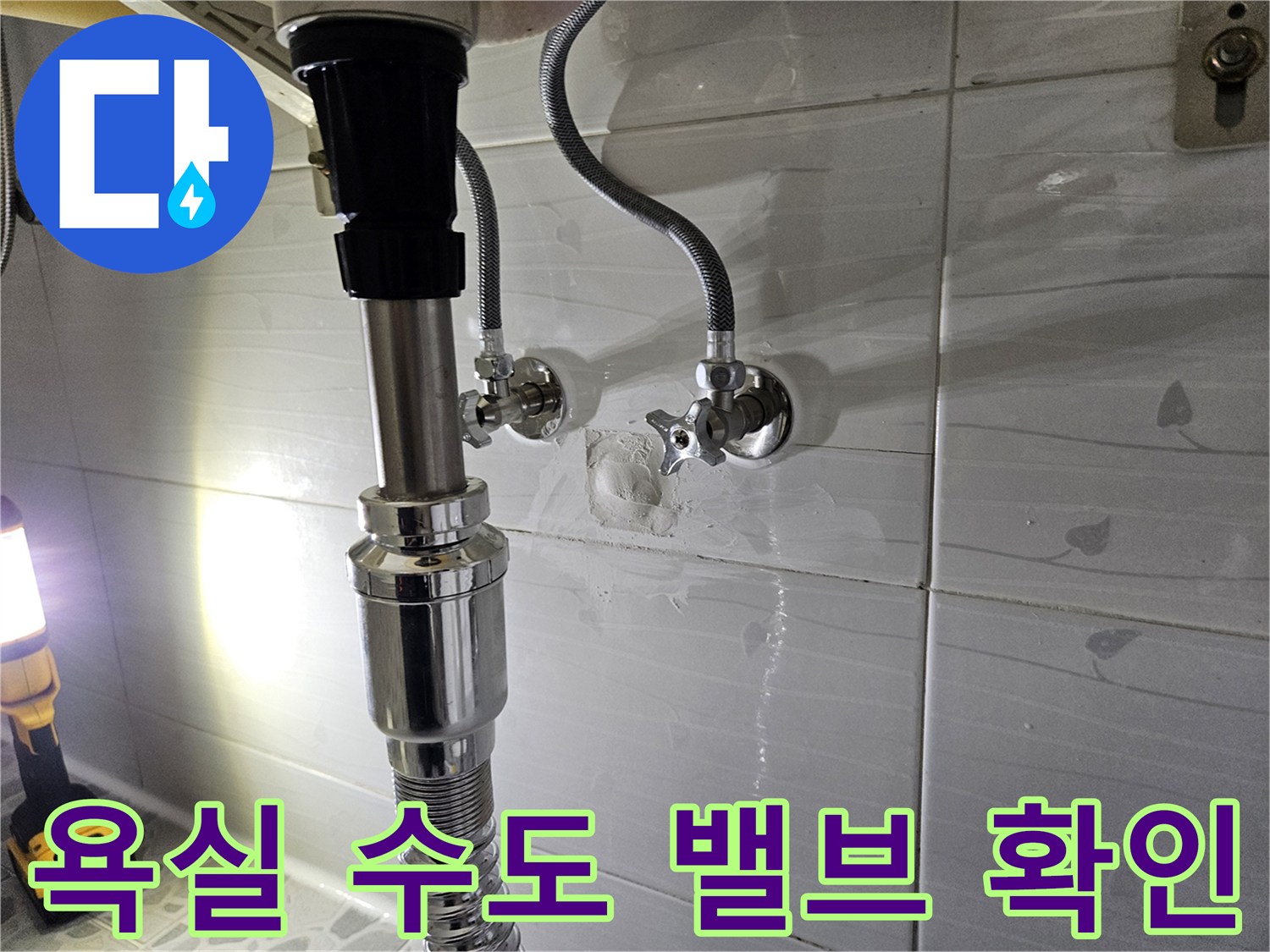 세면대 하부 벽면 수전과 배관 연결 부위의 누수 여부를 점검하는 사진입니다.