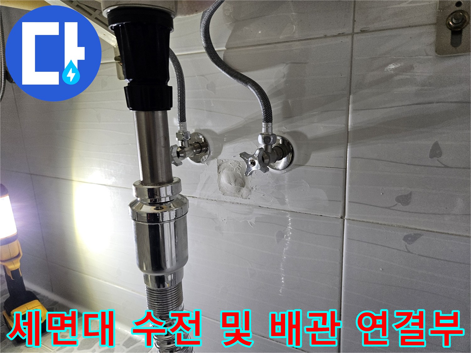 화장실 세면대 하단 벽면 배관과 수전 밸브의 접합 부위 근접 촬영