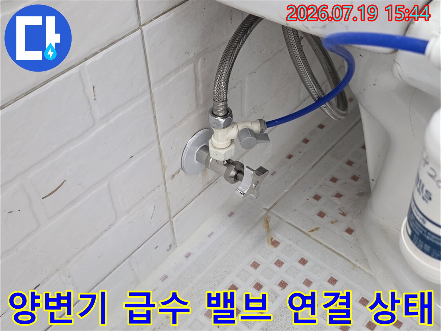 변기 탱크로 진입하는 파란색 플라스틱 호스와 금속 밸브-결합 부위