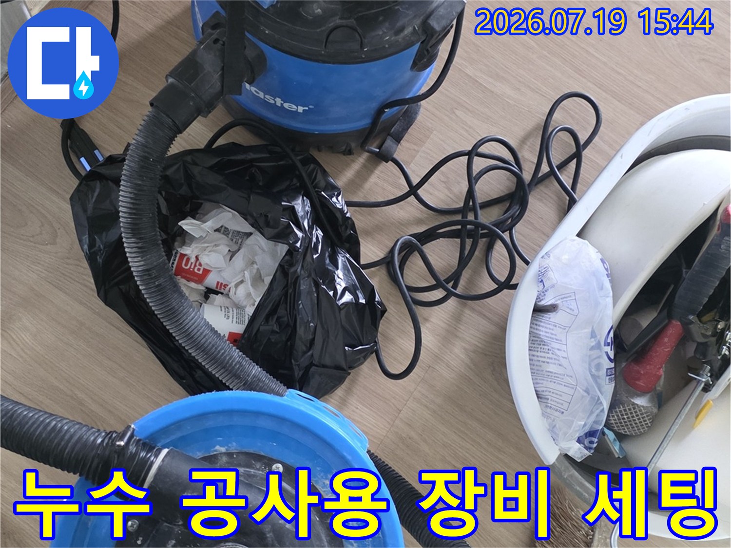 파란색 진공 청소기와 각종 수공구가 담긴 바구니-청소용 빗자루