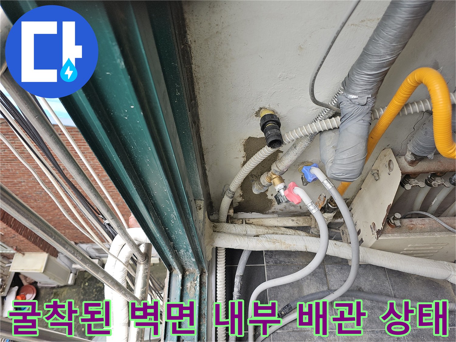 벽면을 일부 걷어내고 드러난 노란색 배선과 은색 부속품의 연결 모습입니다.