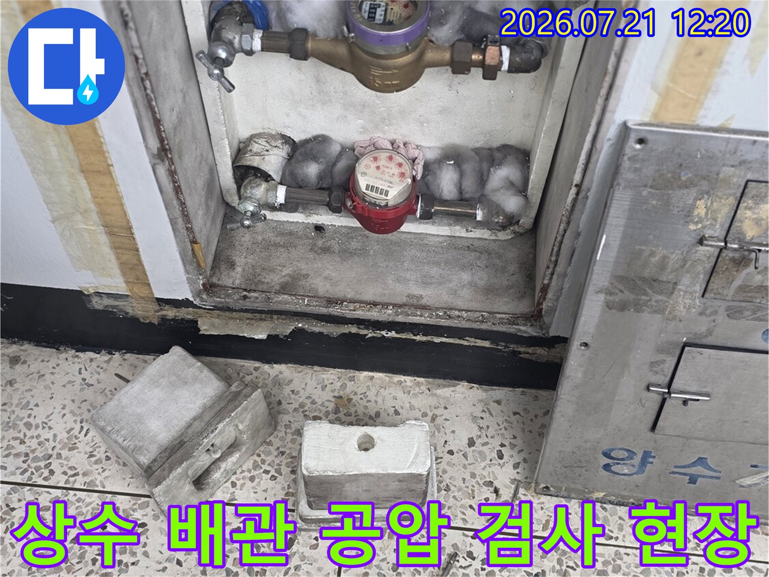 베란다에 노출된 수량계와 수도배관의 이상 여부를 점검하는 과정