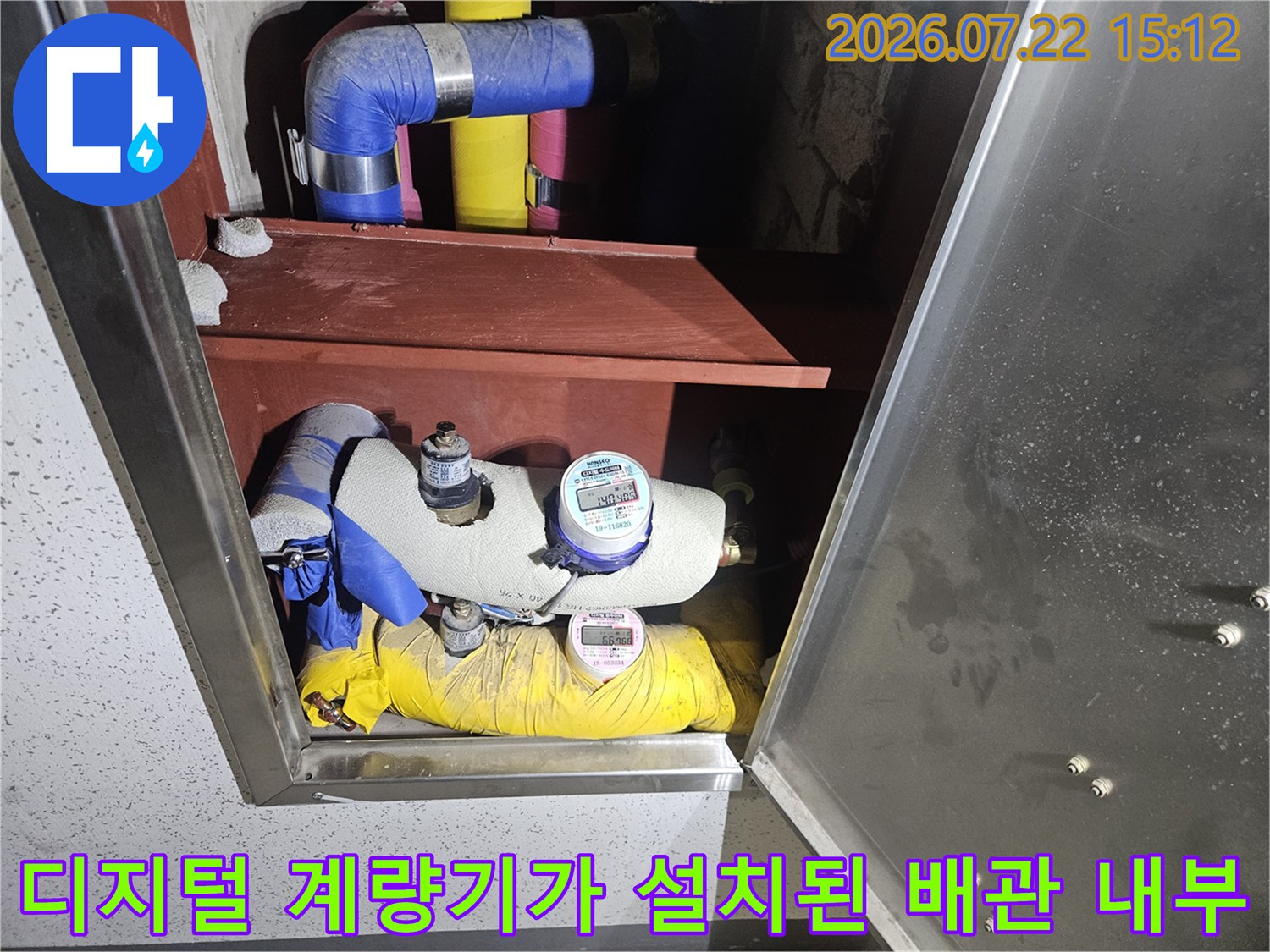 배관 보호재와 함께 상하로 배치된 수도 계량기 장치 사진