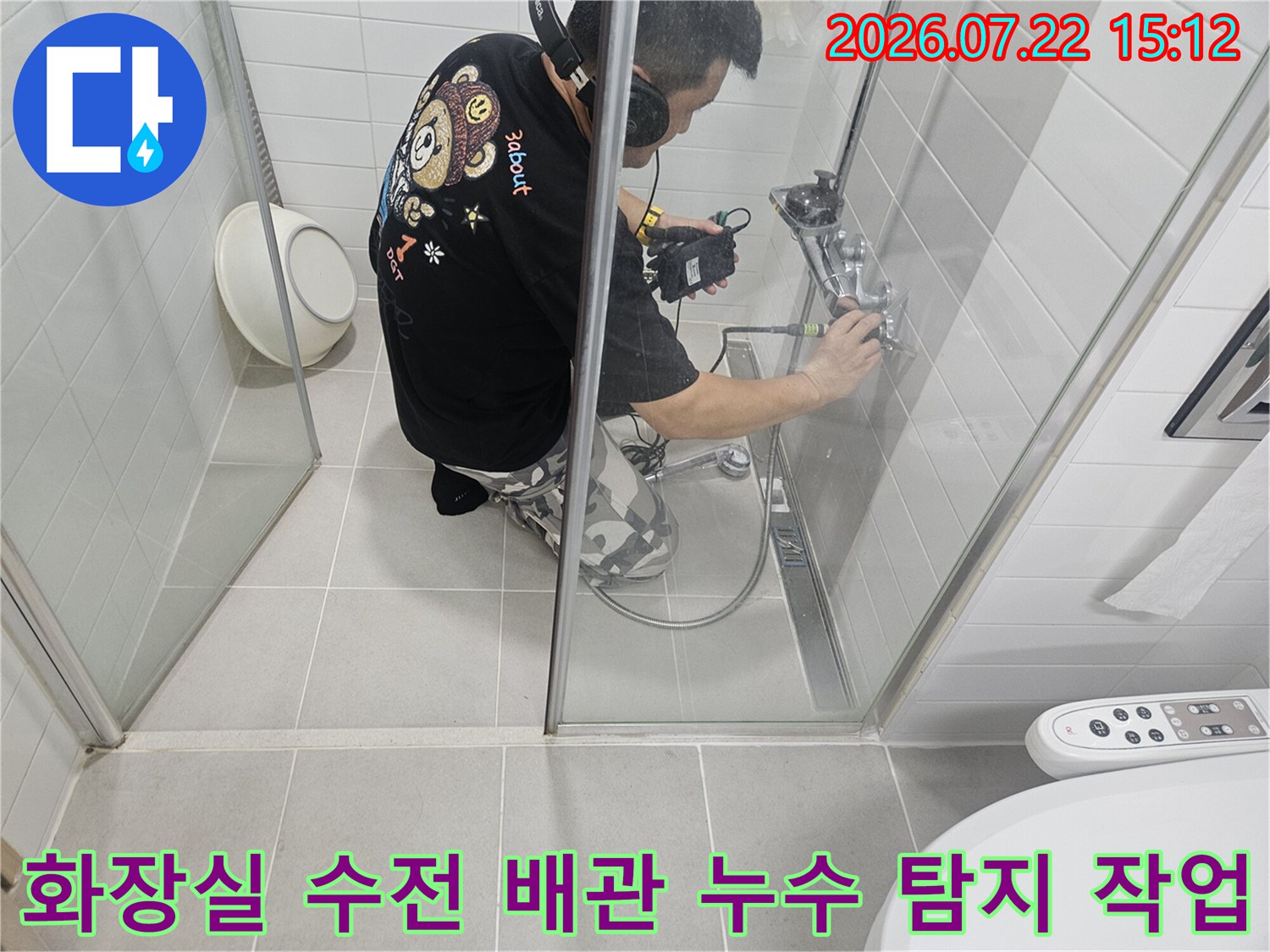 헤드셋을 착용한 엔지니어가 화장실 샤워 수전 부위에서 누수 탐지 장비를 사용해 정밀 점검하는 모습