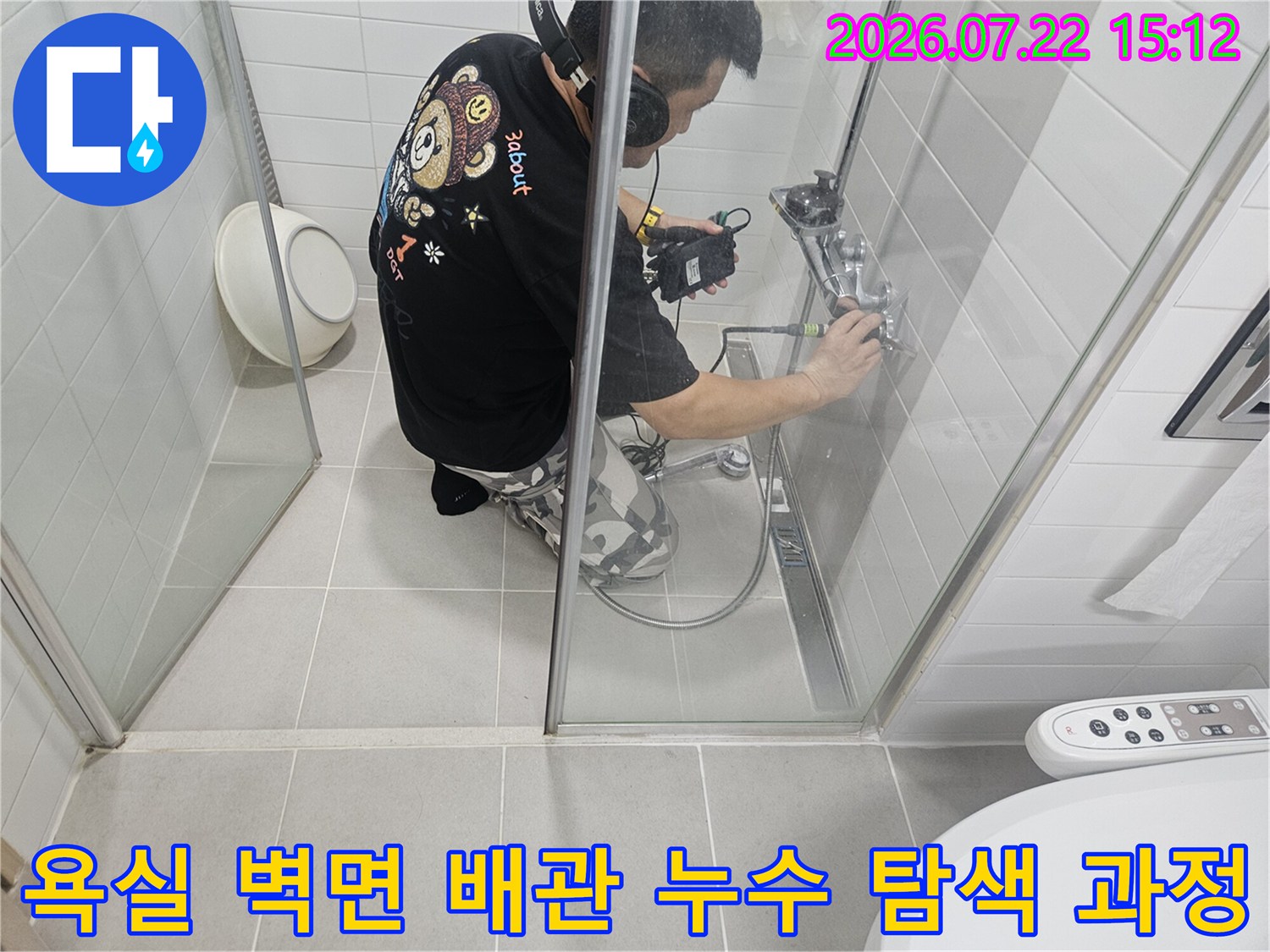 화장실 샤워 시설 벽면에서 전문 장비를 이용해 누수 여부를 확인하고 있는 작업자의 모습