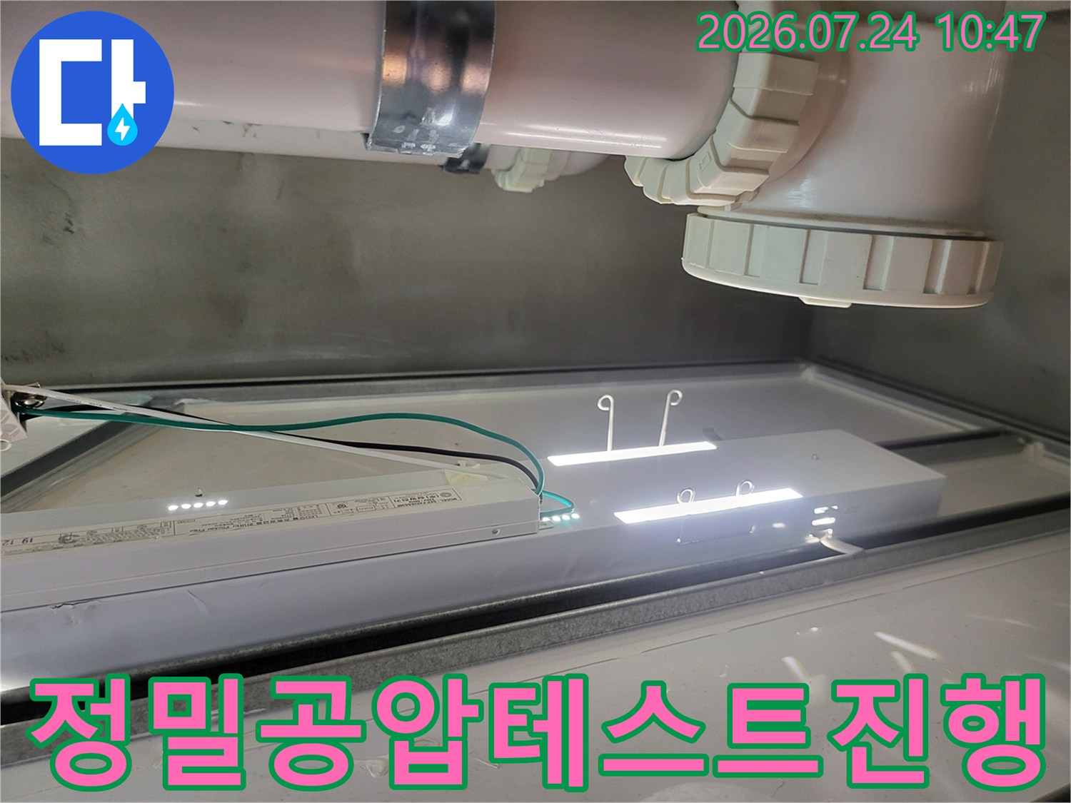 상세 점검을 위해 천장 내부에 조명을 설치하고 배출 배관에 공압 테스트를 실시하는 모습