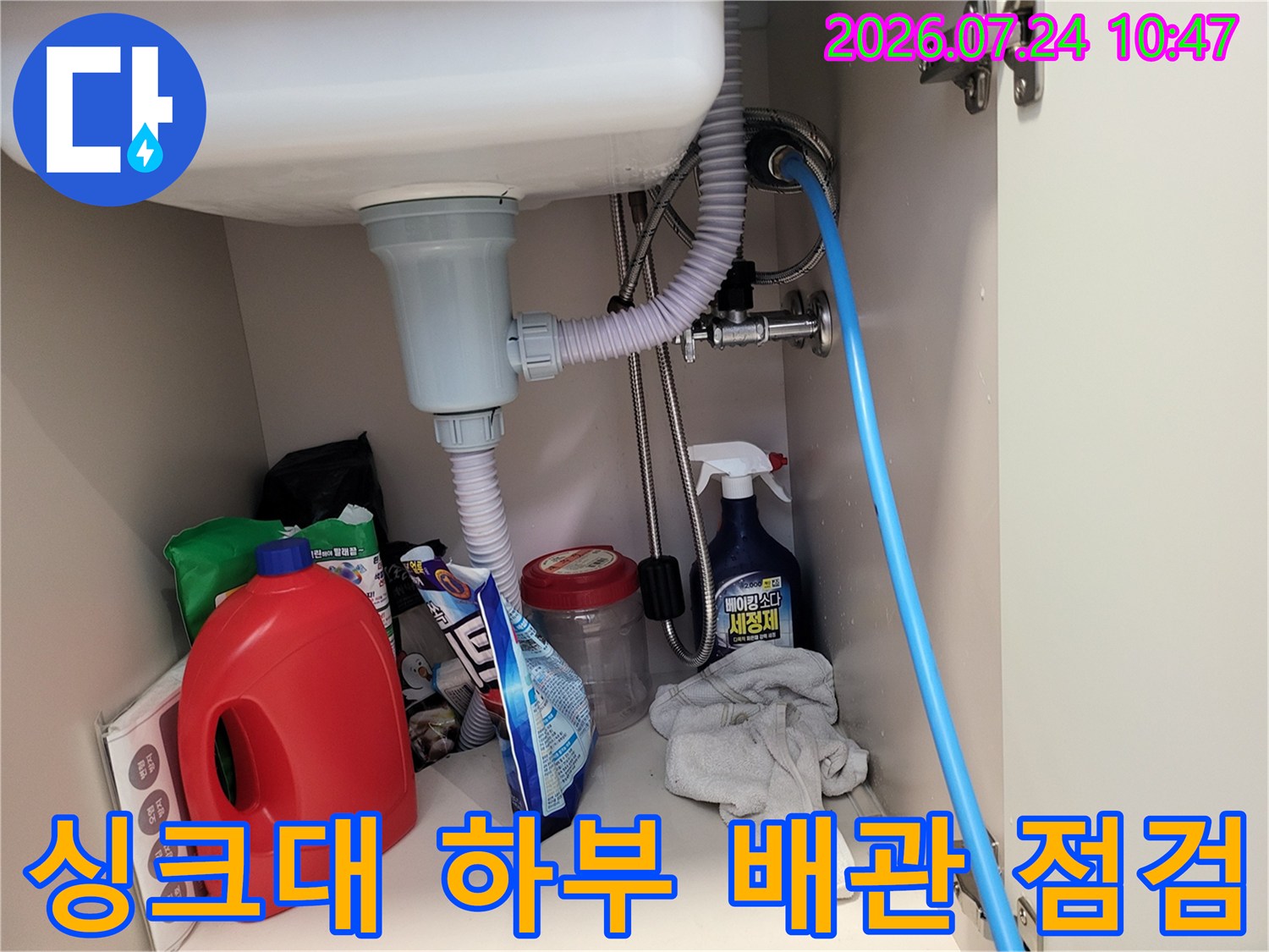 싱크대 아래 설치된 배수관과 공압 테스트용 호스가 연결된 모습