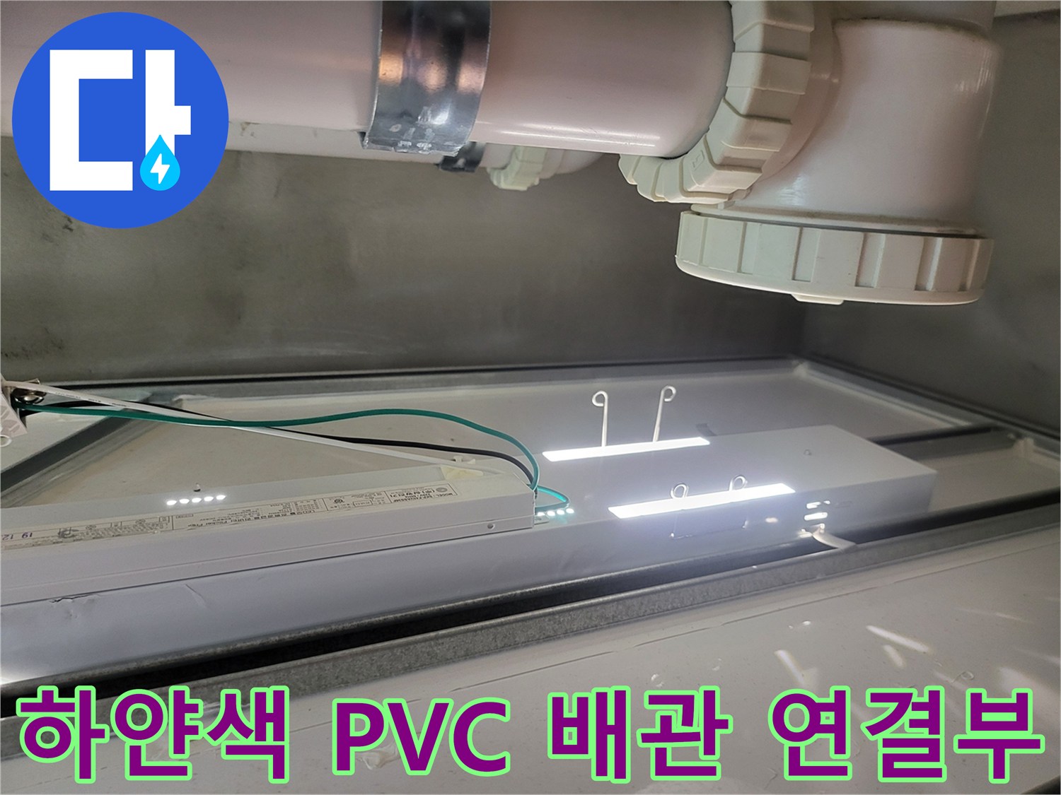 화장실-천장에-연결된-PVC-배관과-연결-소켓-근접-사진