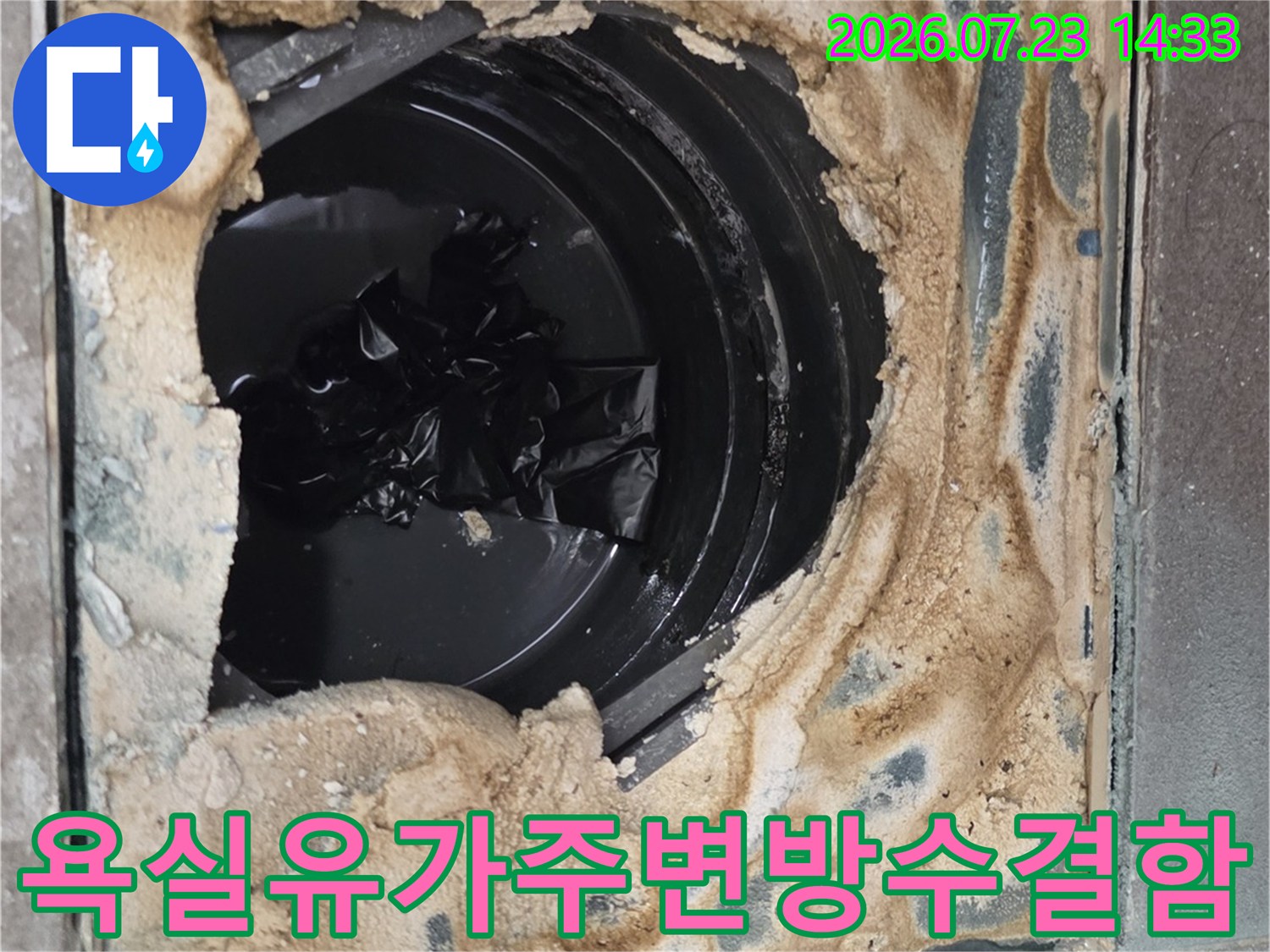 타일이-제거된-사각형-공간-중앙에-배수관이-위치하고-주변은-습기로-오염된-모습