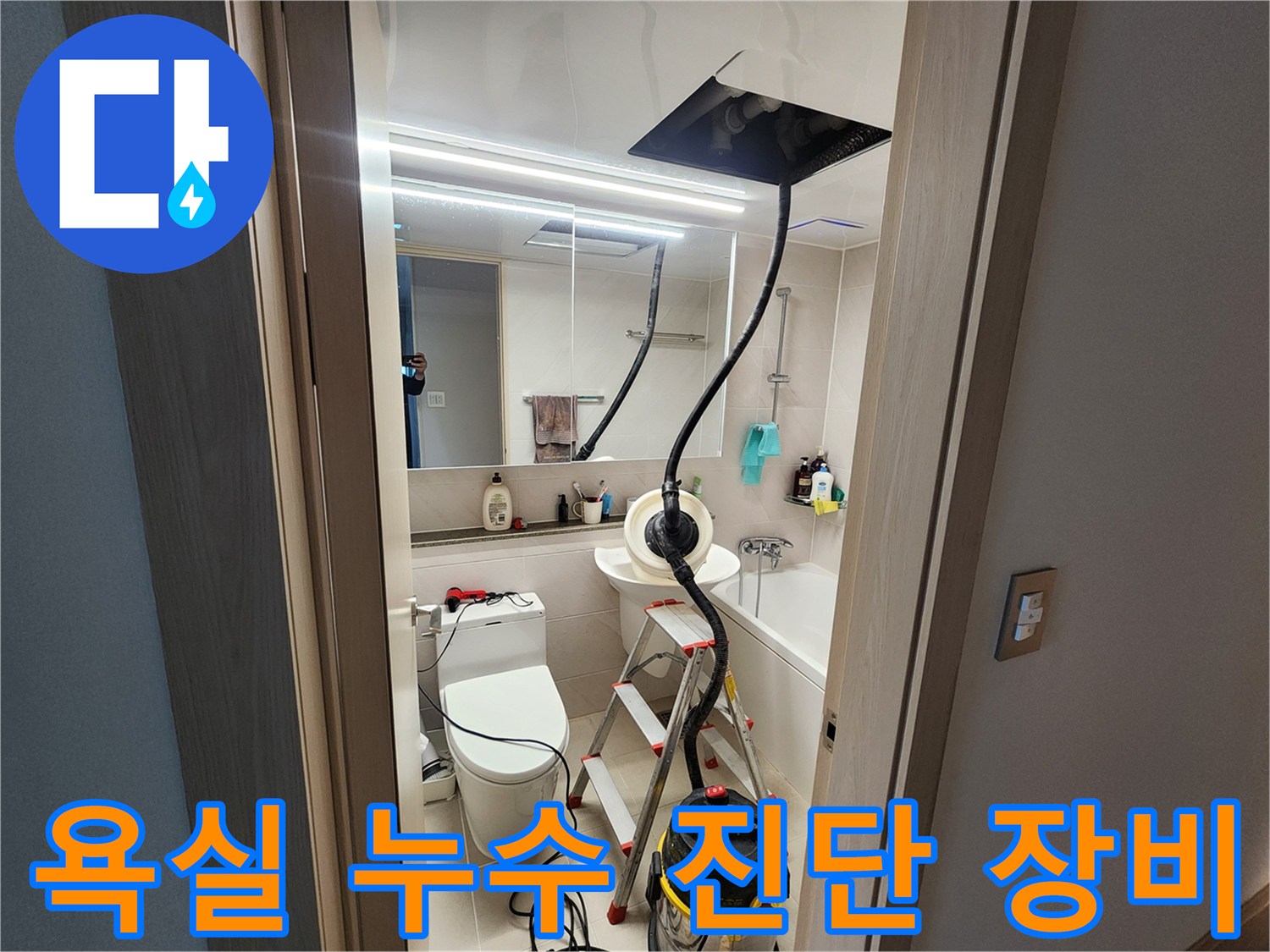 누수 점검을 위해 사다리와 청소기를 배치한 화장실 내부 전경
