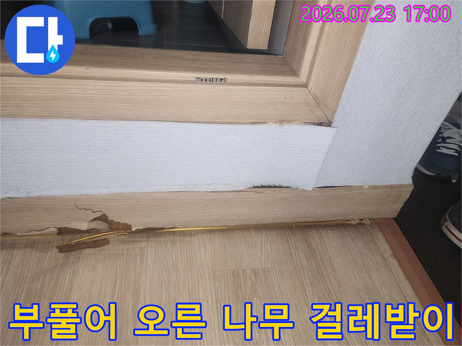 누수로 인한 습기 때문에 갈라지고 훼손된 거실 하단 마감재 사진