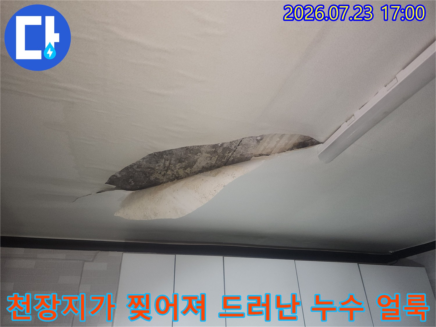 습기로 인해 일부가 벗겨진 천장지와 내부에 형성된 짙은 누수 얼룩-피해 사진