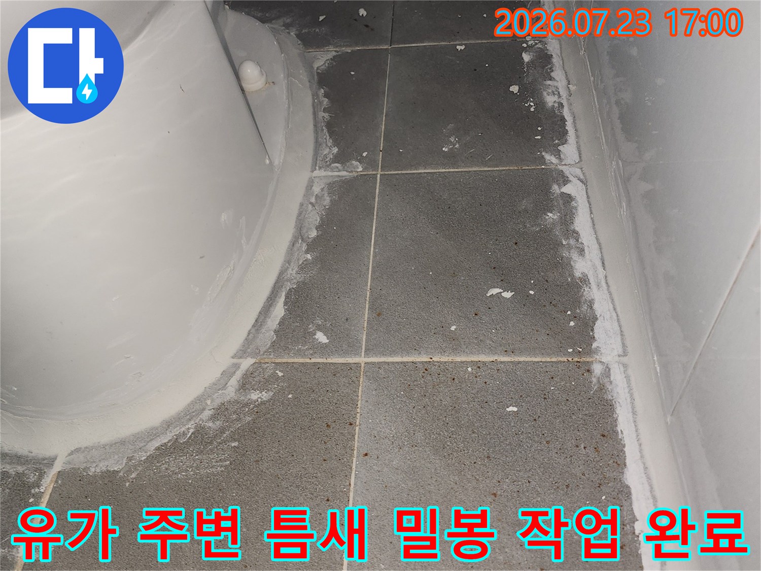 하얀색 배수 시설과 회색 타일의 연결 부위에 방수 실리콘이 시공된 사진
