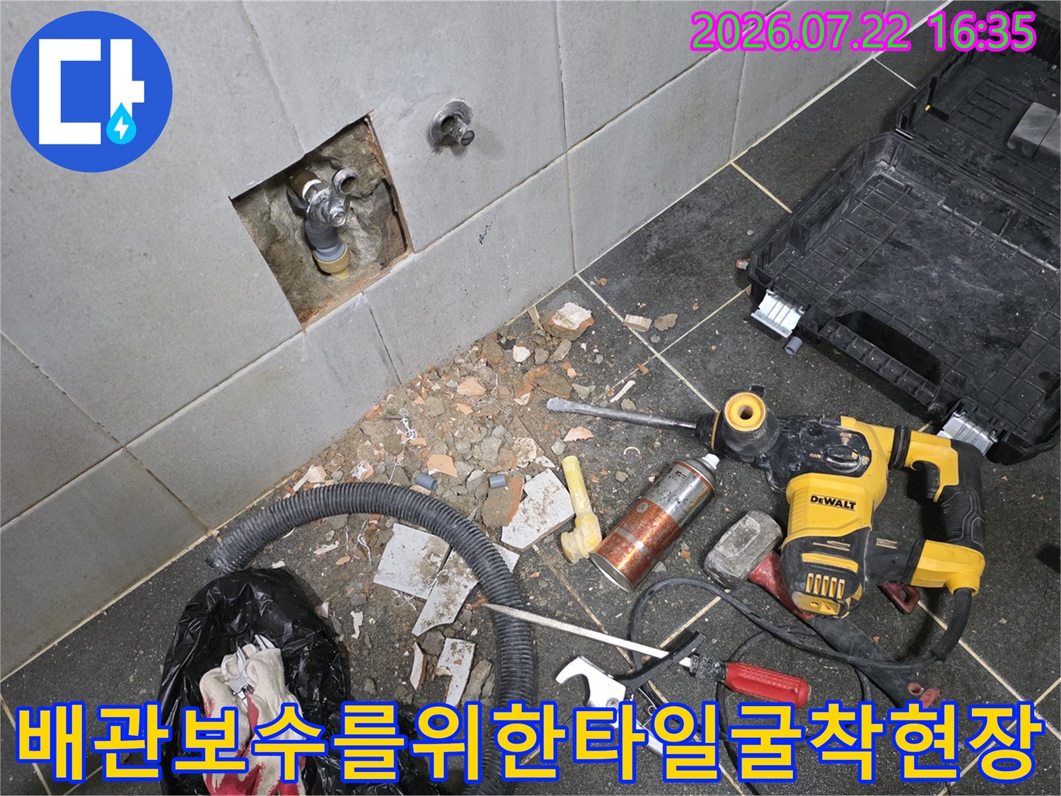 벽면 타일이 사각형으로 제거되어 내부 수도 배관 연결부가 노출된 현장 사진