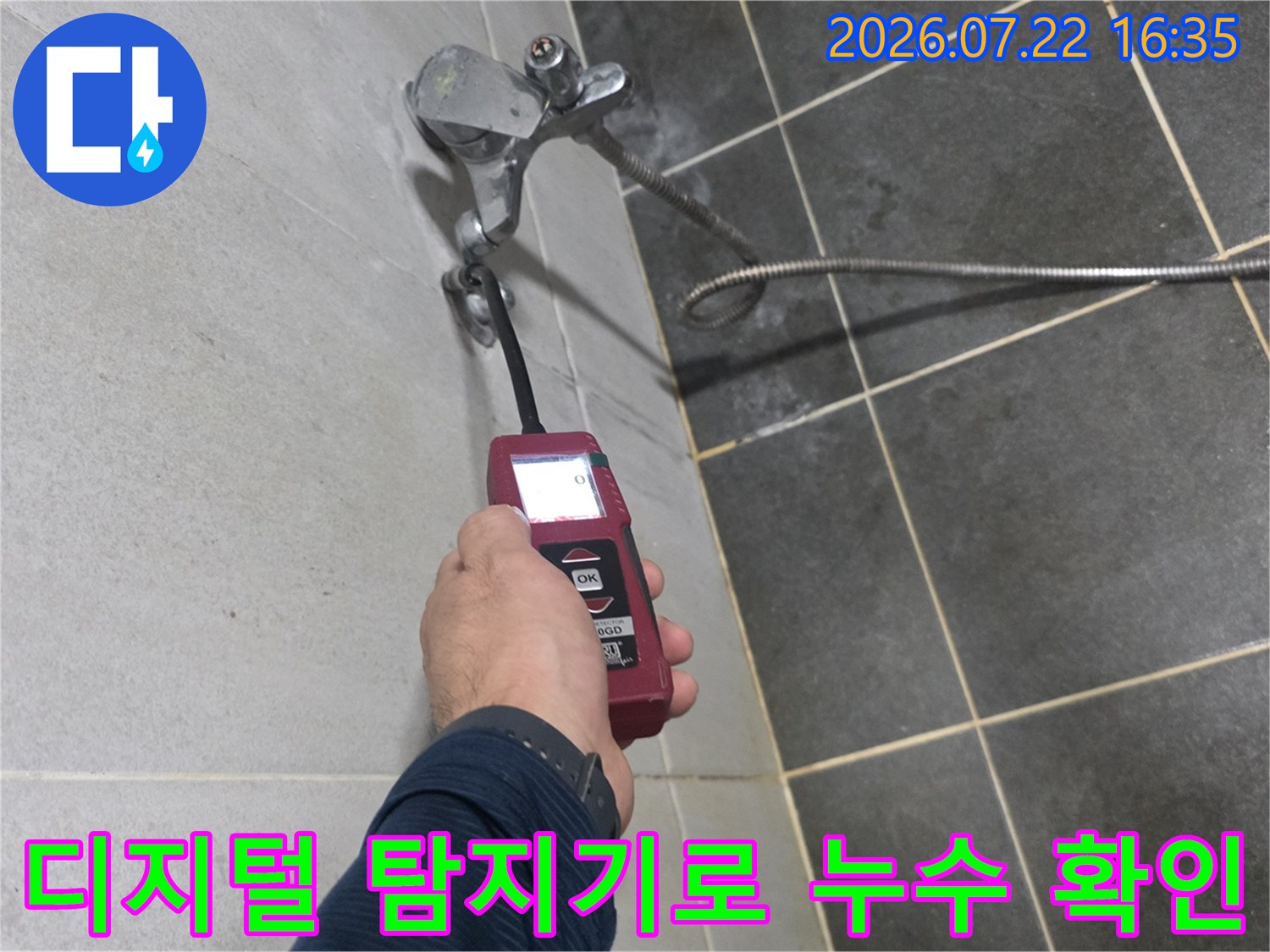 엔지니어가 디지털 누수 탐지기를 사용하여 벽면 배관의 누수 지점을 정밀하게 측정하는 모습