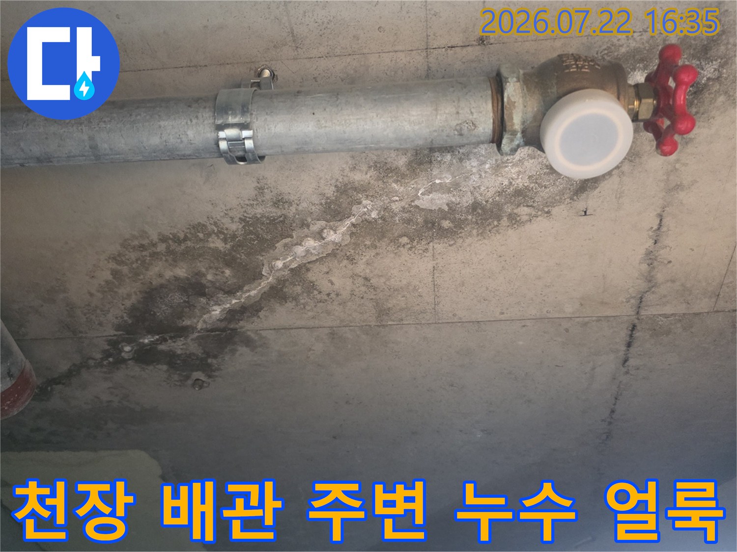 콘크리트 천장에 설치된 금속 배관과 그 주변으로 넓게 퍼진 누수 얼룩-모습