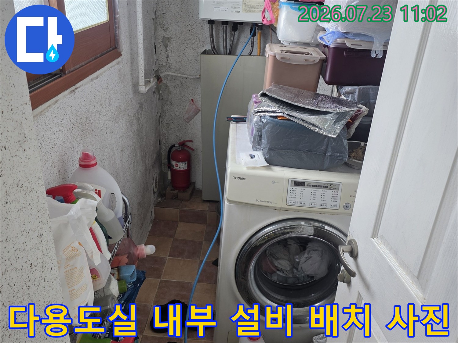 흰색 보일러와 드럼세탁기가 설치된 다용도실의 전반적인 모습