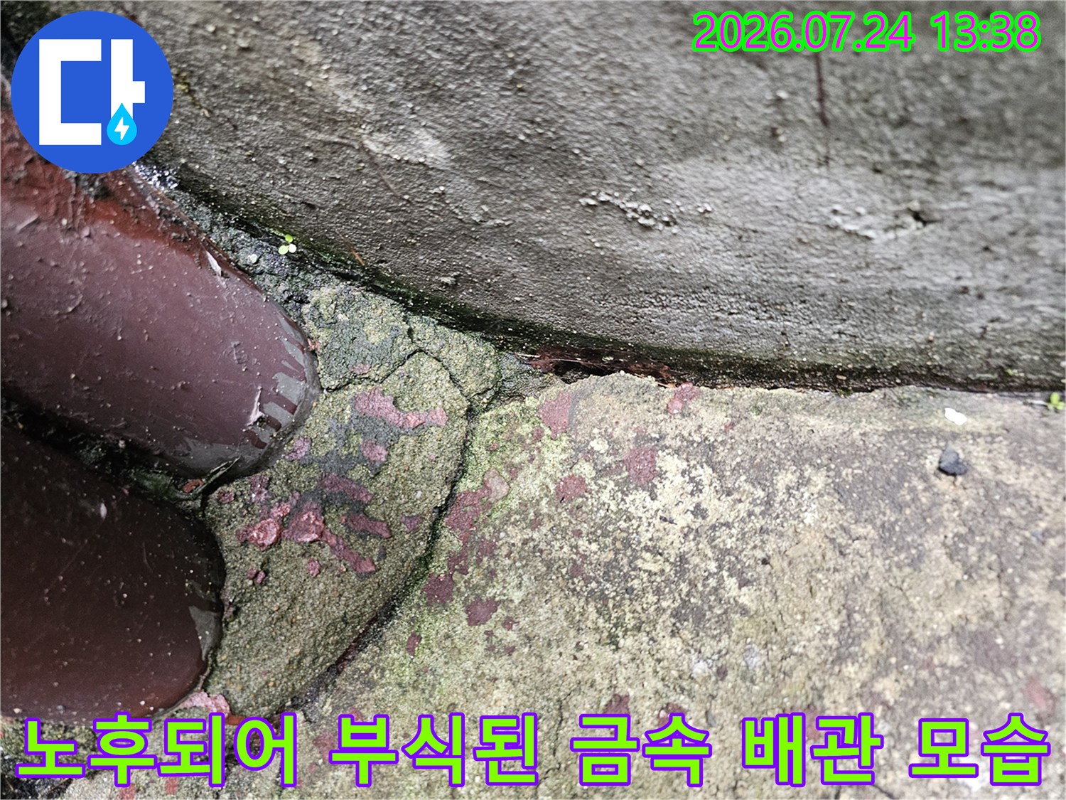 갈색으로 변색된 노후 배관-그리고 주변의 거친 콘크리트 표면 사진