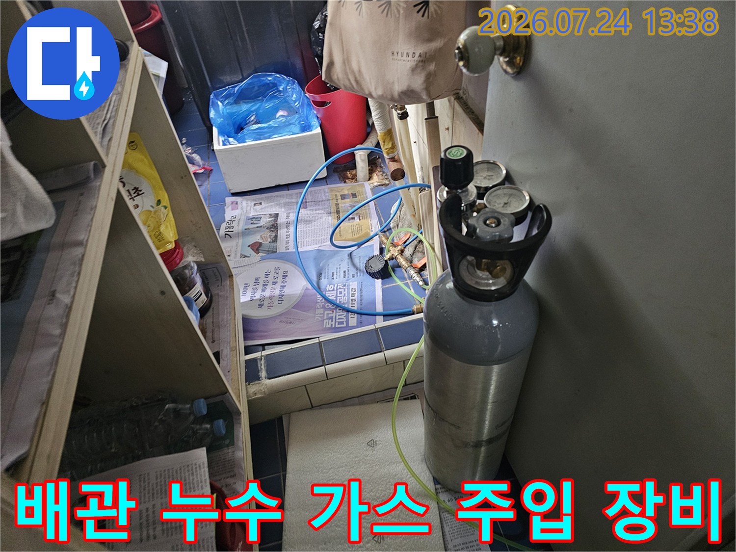누수 탐지를 위해 준비된 회색 가스통과 연결된 다채로운 색상의 호스들