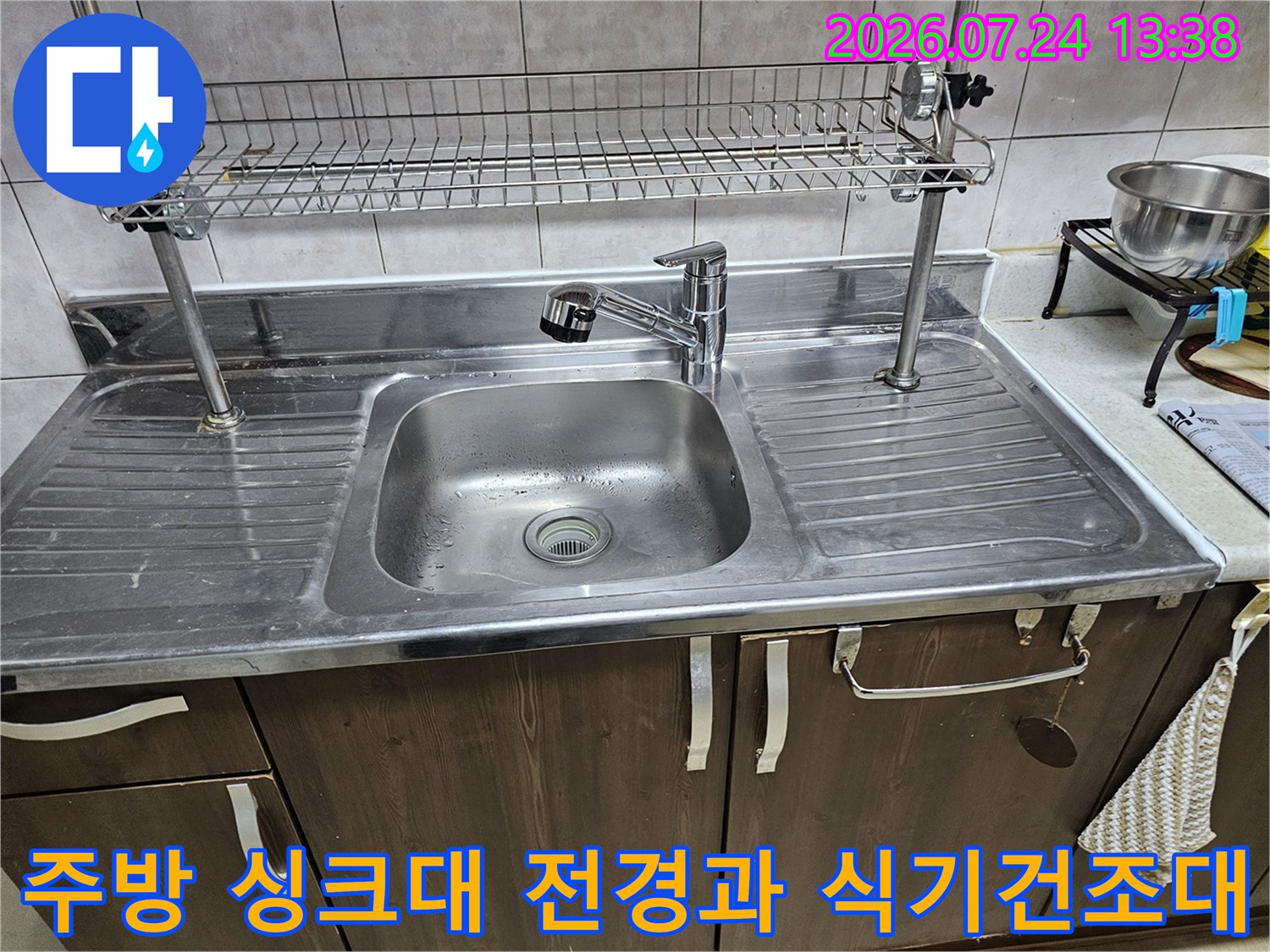 스테인리스 소재의 주방 싱크대-상단에 설치된 금속제 식기 건조대와 수전 모습