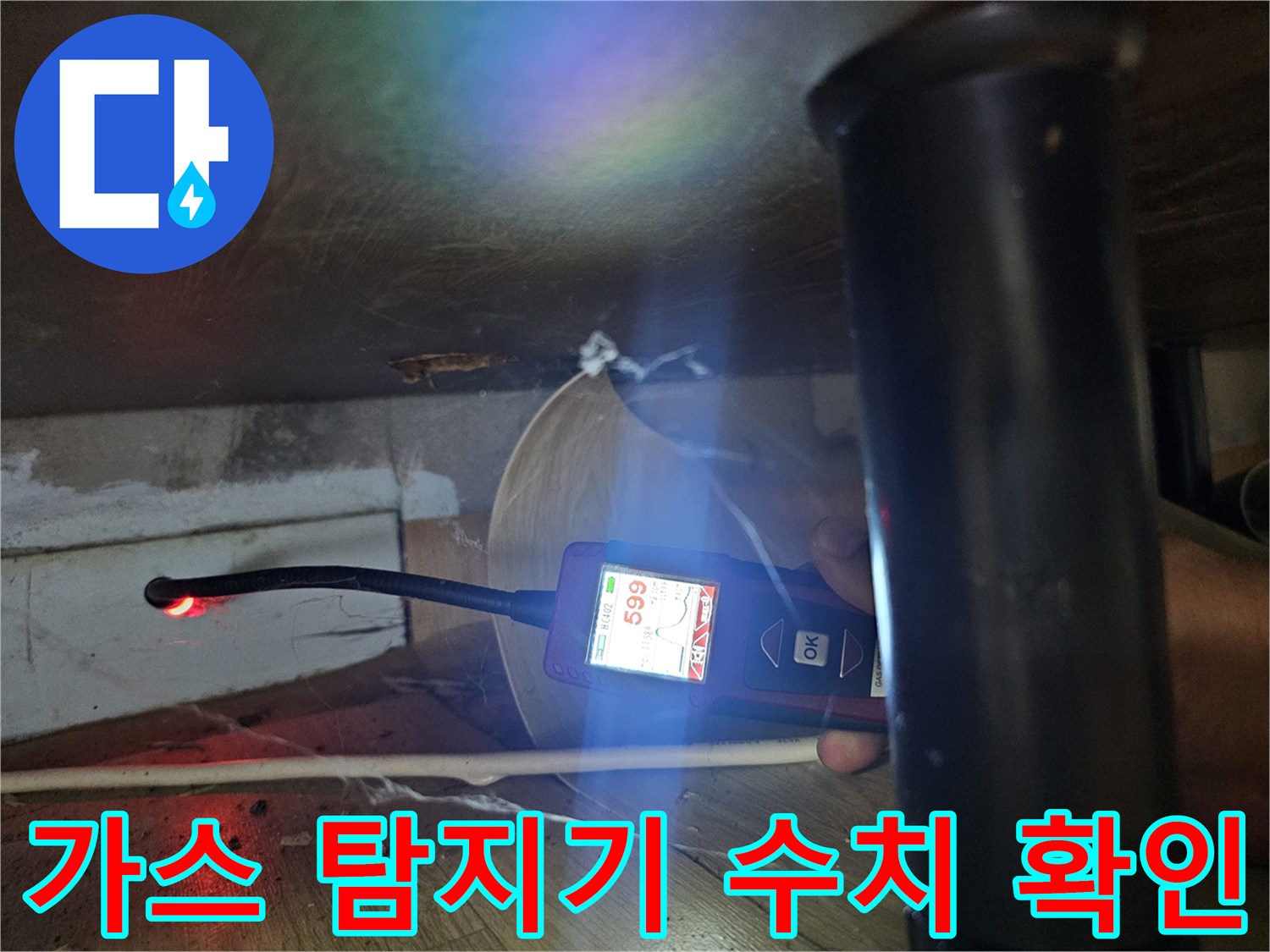 싱크대 하부 공간에서 가스 탐지기로 배관 압력을 체크하는 모습입니다.