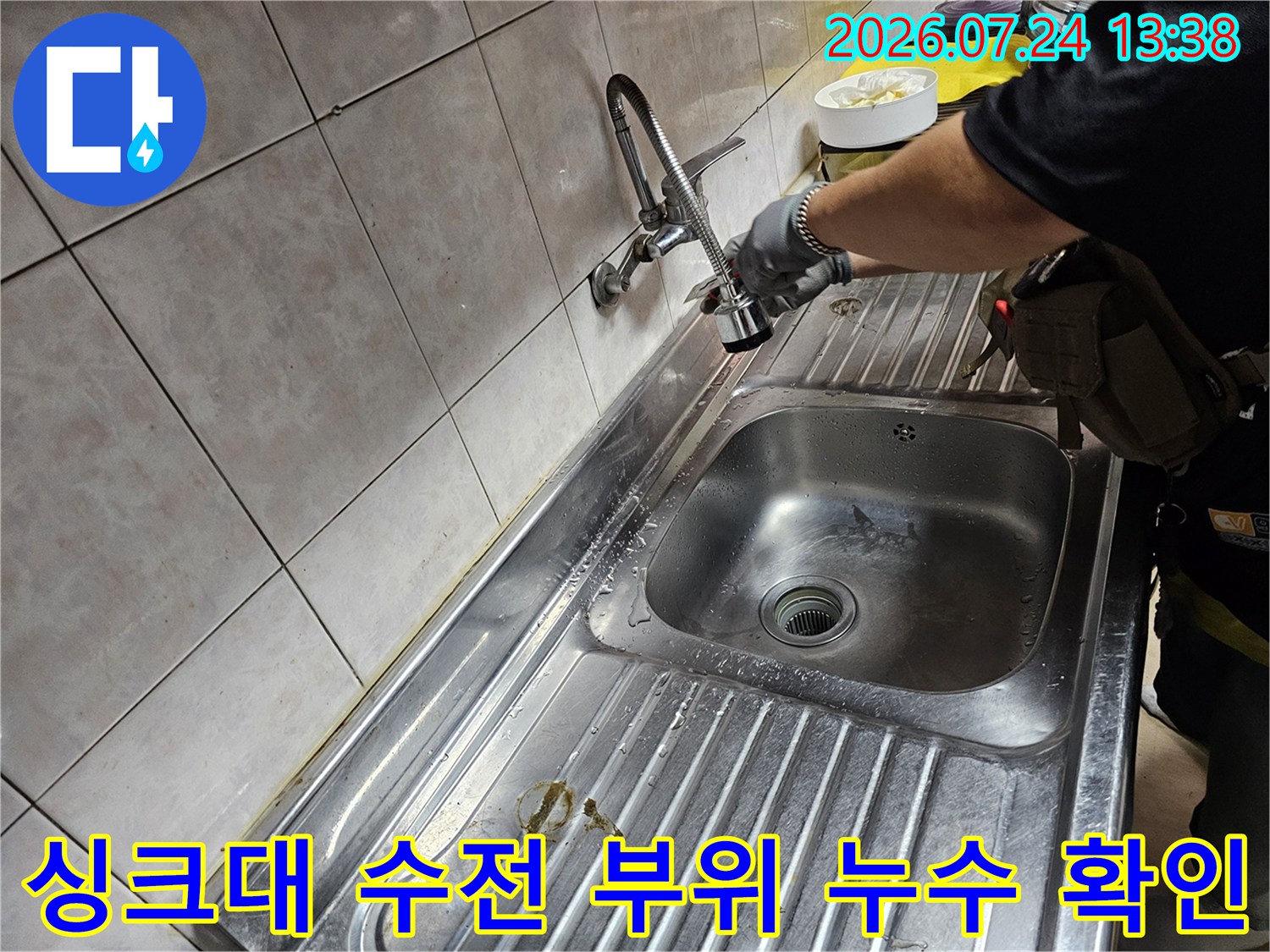엔지니어가-주방-싱크대의-금속-수전-연결부를-손으로-짚으며-점검하는-모습