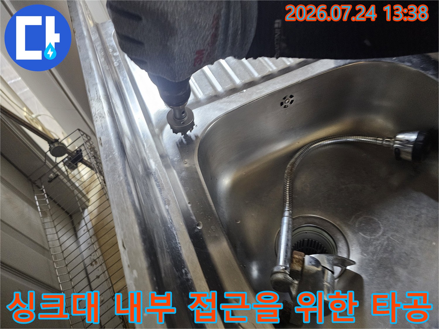 작업용 장갑을 착용한 상태에서 홀쏘 드릴로 싱크대 상판의 모서리 부분을 뚫고 있는 모습