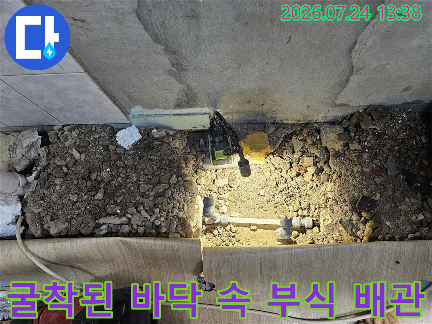 작업용 조명 아래로 드러난 낡은 금속 배관-누수 지점 사진