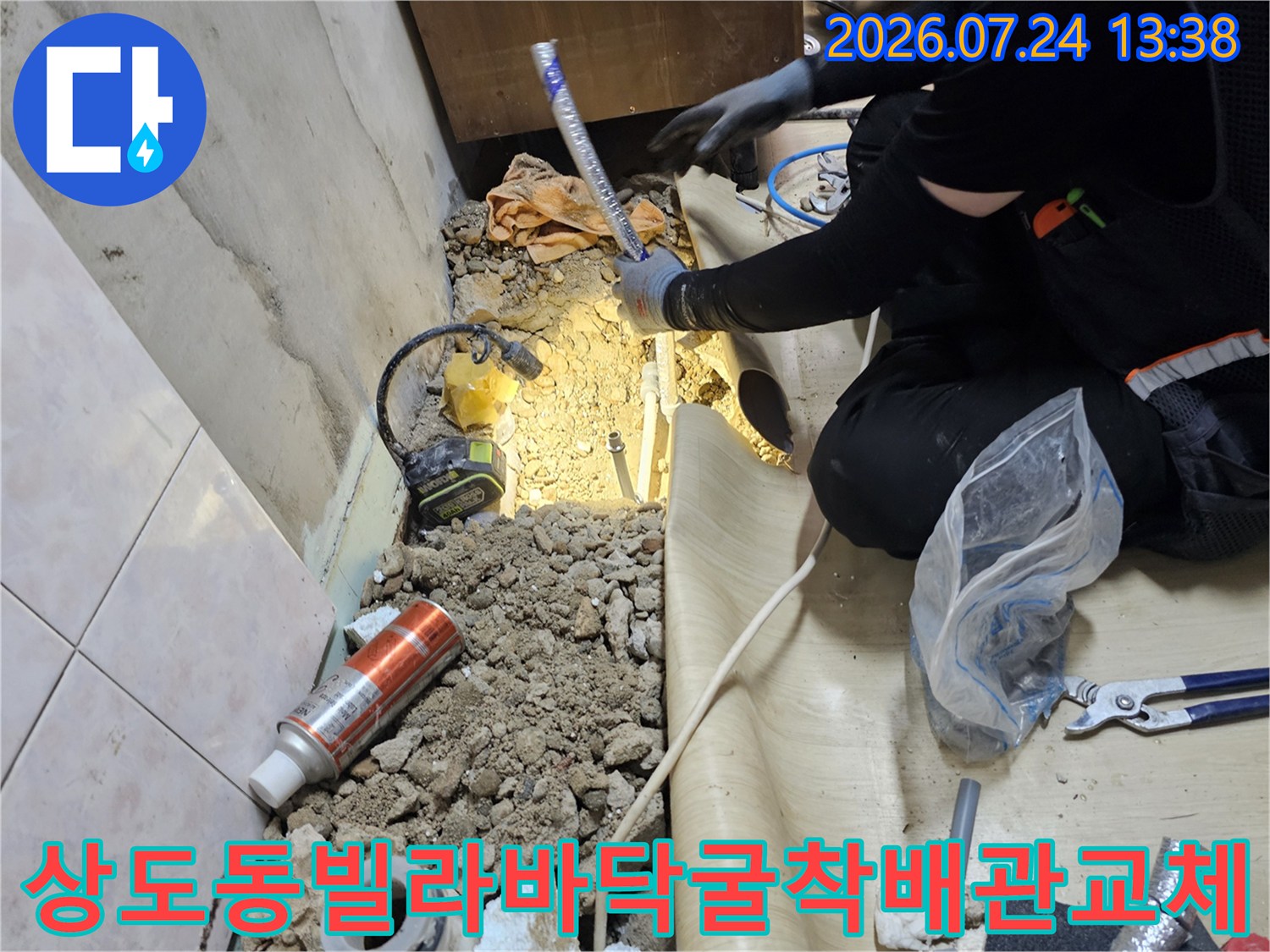 작업자가 굴착된 바닥 면에서 파란색 보온재가 씌워진 새로운 배관을 연결하고 있는 모습