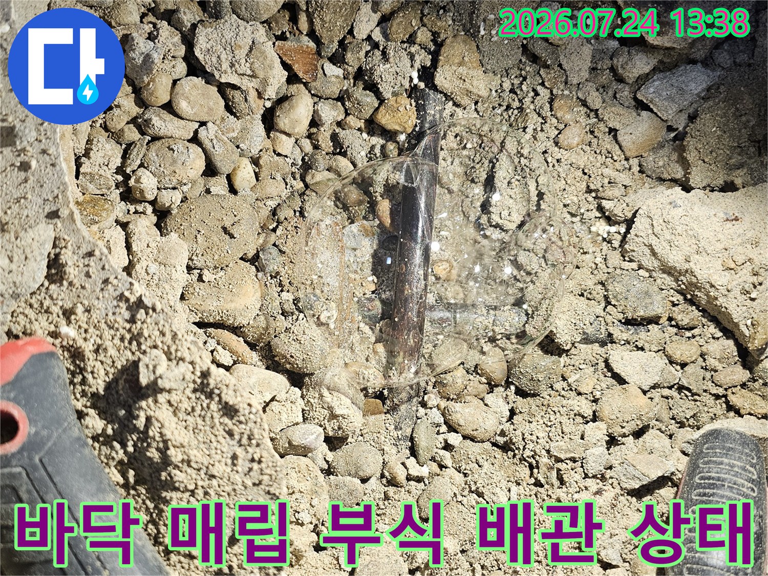 흙과 자갈 속에 묻혀 있던 부식된 금속제 누수 배관-손상 부위 노출