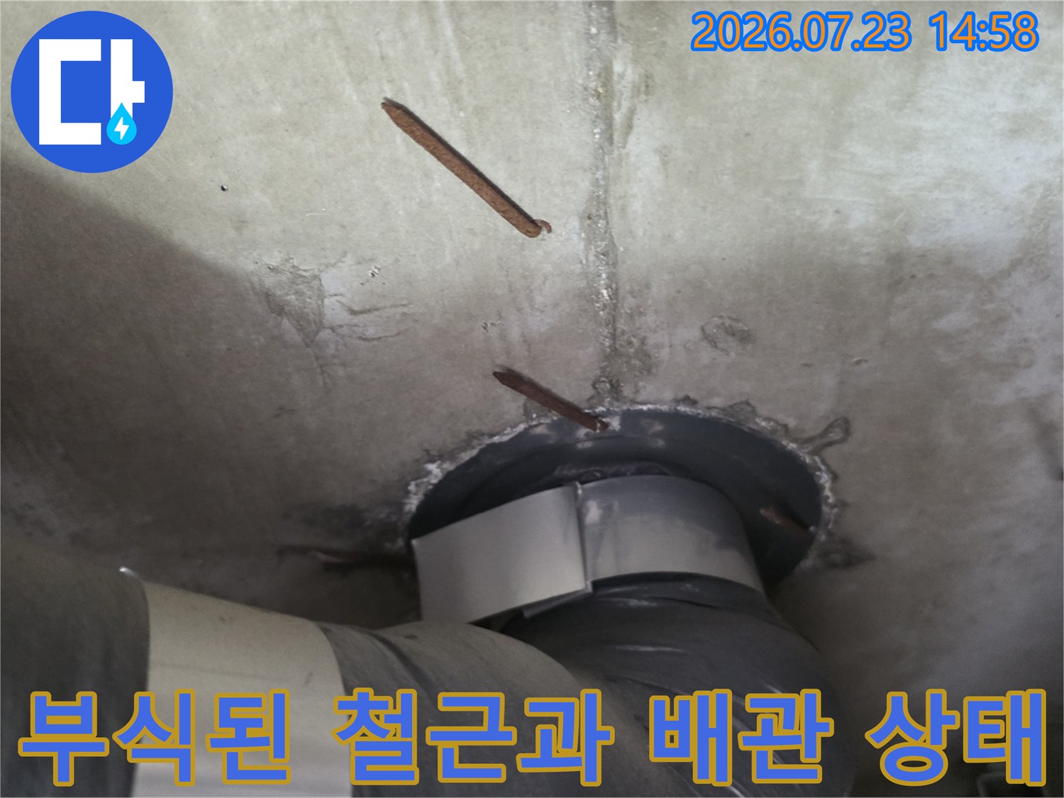 천장 콘크리트 슬라브에서 노출된 부식 철근-배관 연결 지점 사진
