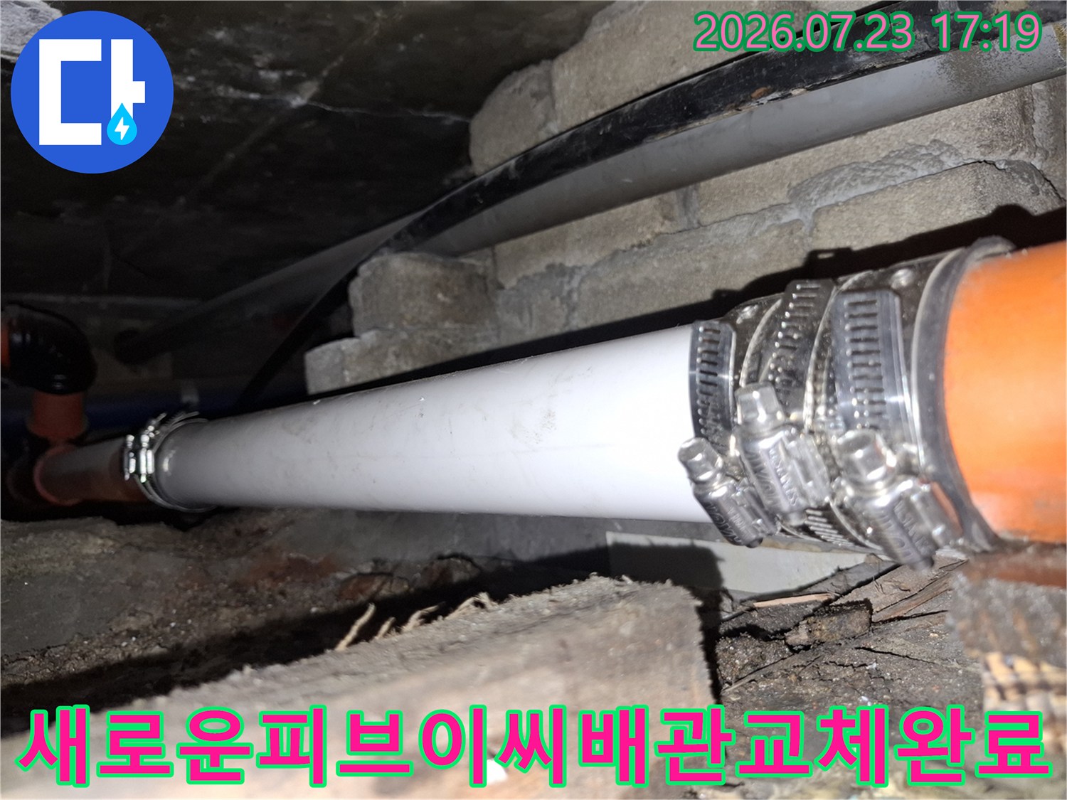 부식된 구간을 제거하고 흰색 신규 배관을 삽입하여 연결 밴드로 마감한 배관 모습