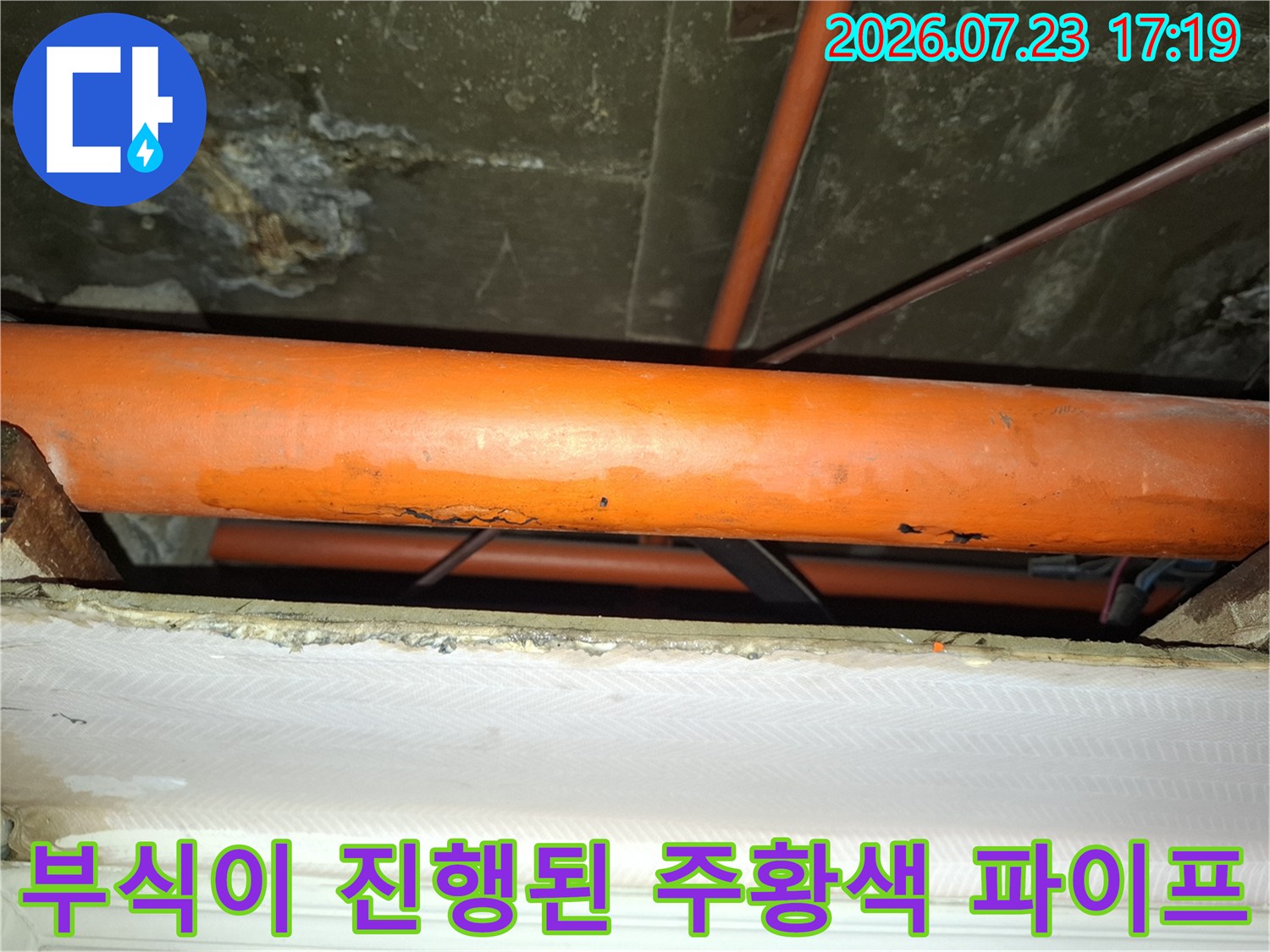 천장 속에 매립된 노후된 오렌지색 배관의 부식된 표면 상세 사진