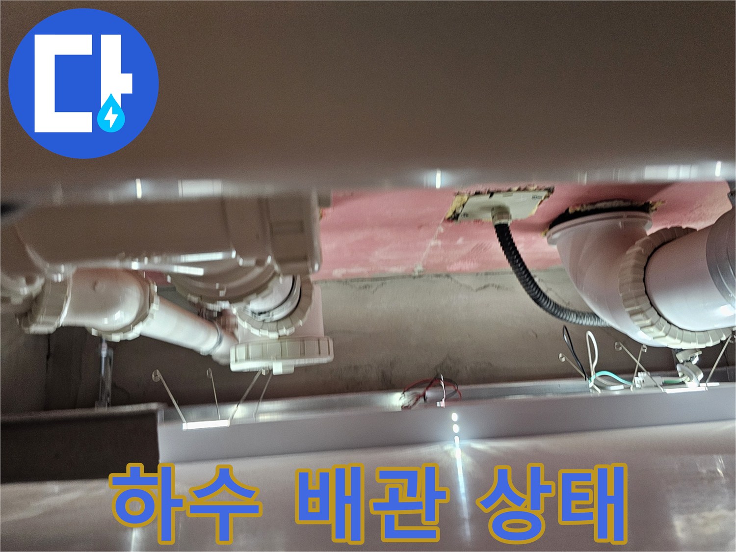 화장실 천장에 노출된 하수도 배관과 전기 배선 구조