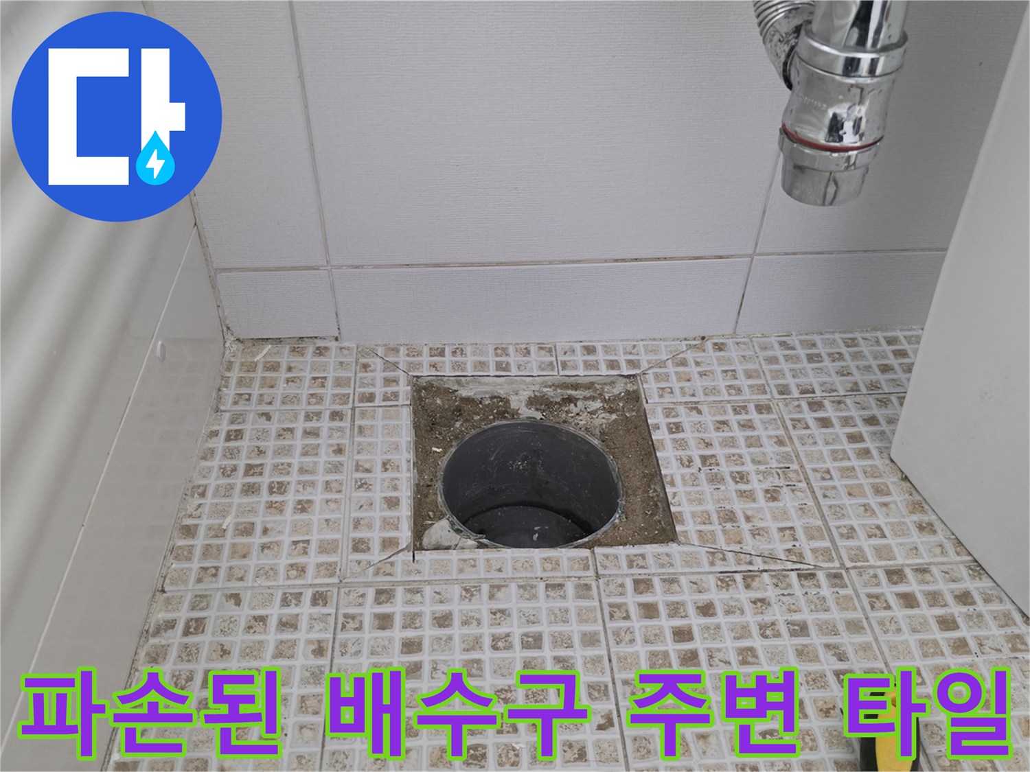 배관 입구 주변의 깨진 타일과 노출된 배수구 내부 모습