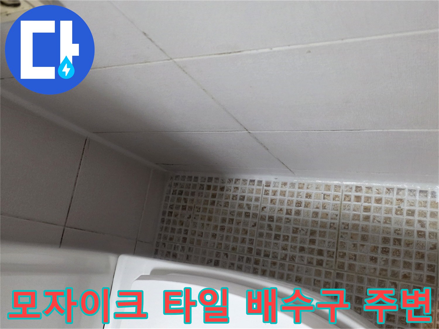 배수구 근처의 모자이크 타일과 벽면 타일 경계부