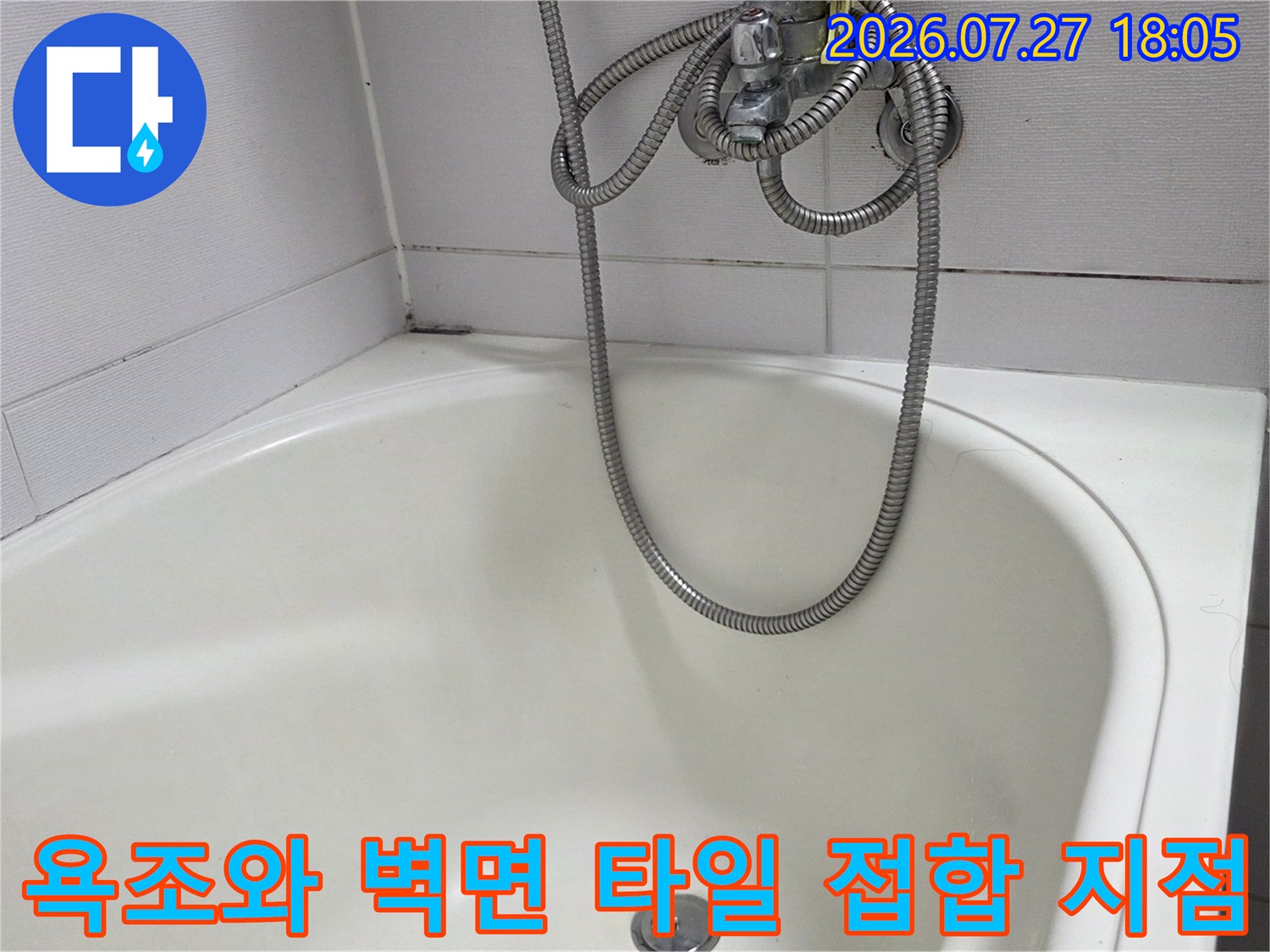 욕조의 곡선 부분과 직선 형태의 벽면 타일이 맞닿은 경계-샤워 호스 노출