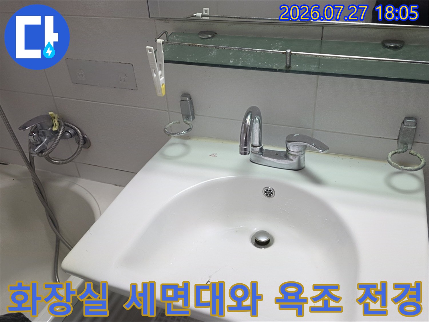 흰색 세면대와 은색 수전 그리고 옆에 배치된 욕조-욕실 내부 모습