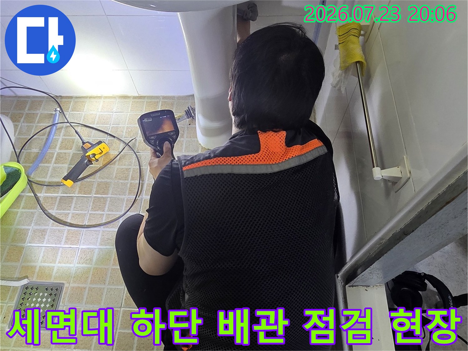 전문가가 세면대 밑 노출된 배관을 정밀 장비로 체크하는 모습