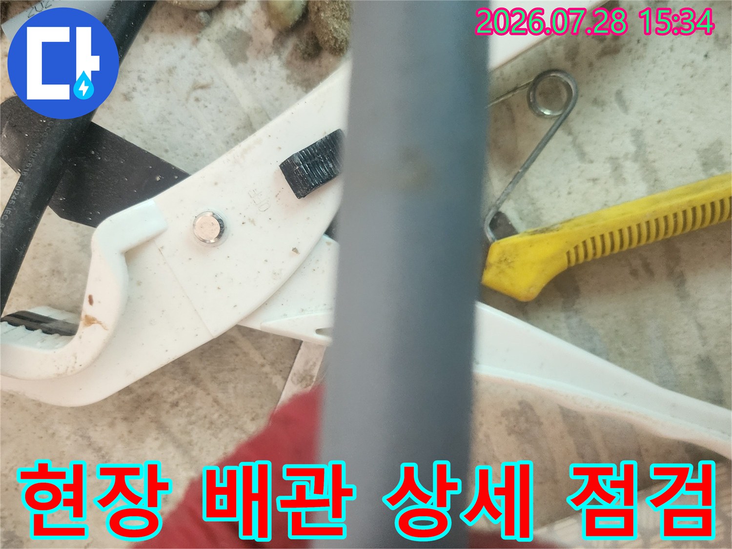 노출된 회색 수도 배관과 공구가 배치된 현장 전경