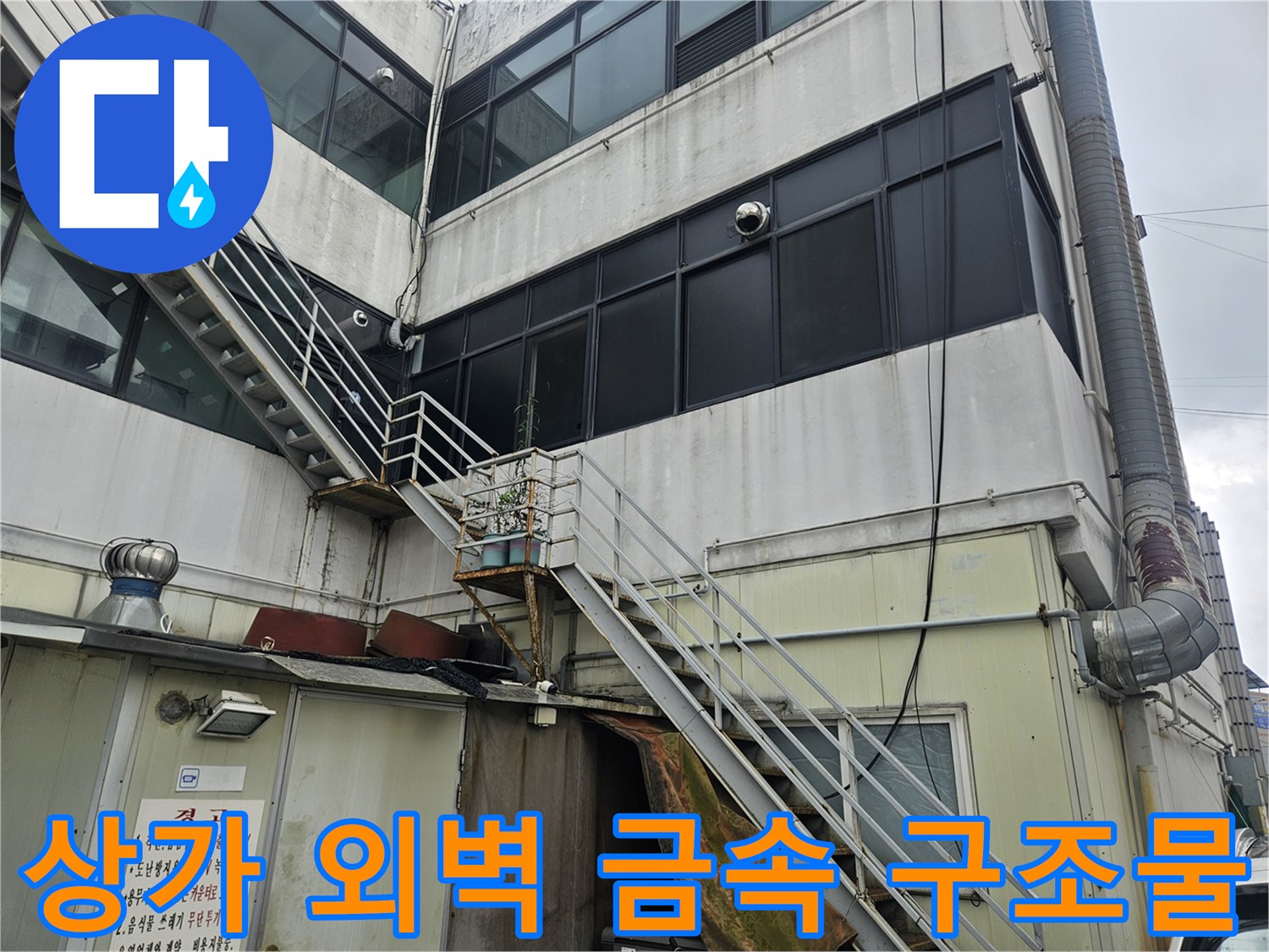 건물 외벽에 설치된 금속 난간과 연결된 배관 시설물
