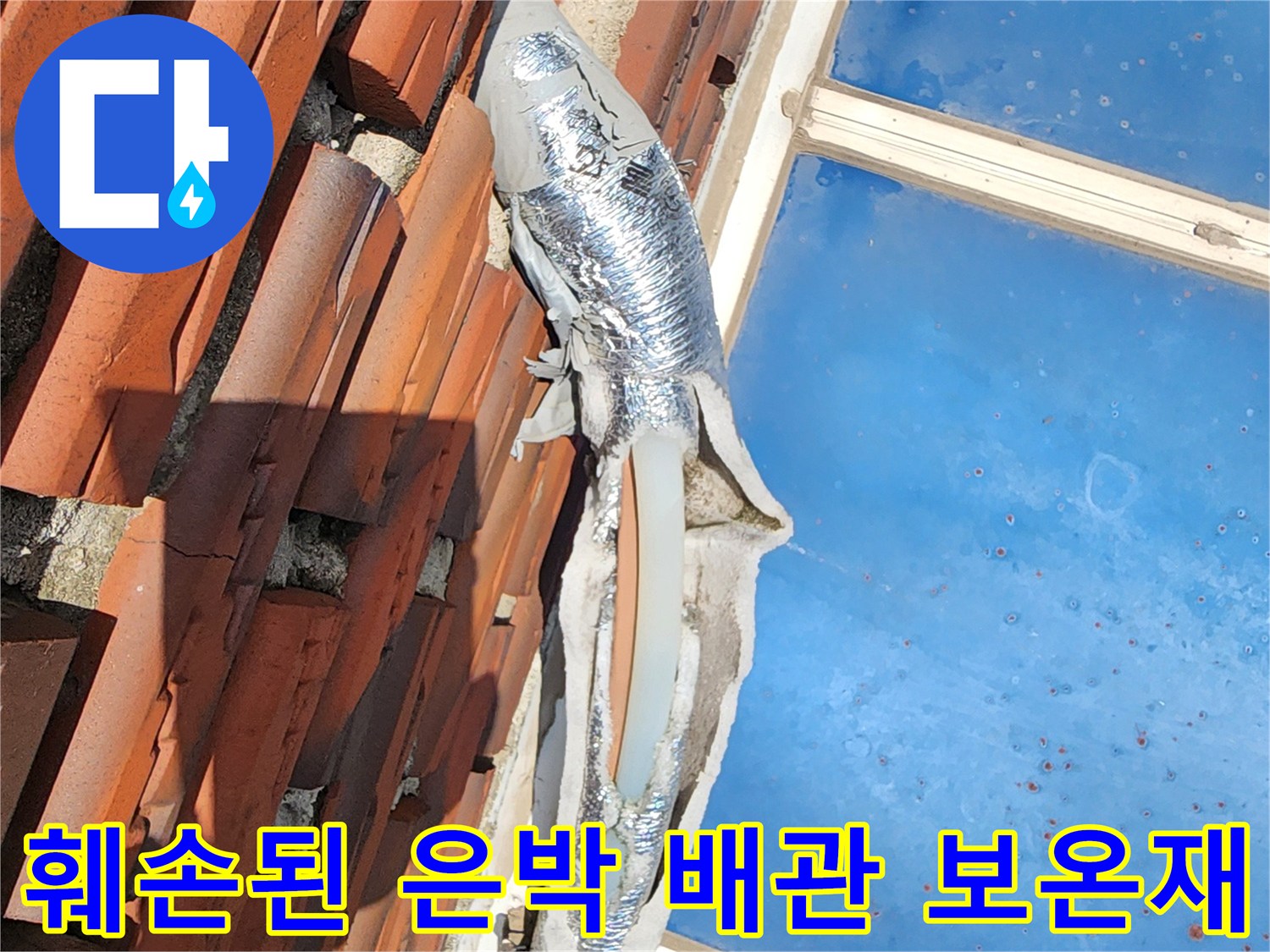 기왓장 아래 찢어진 은박 보온재로 감싸진 배관 부위