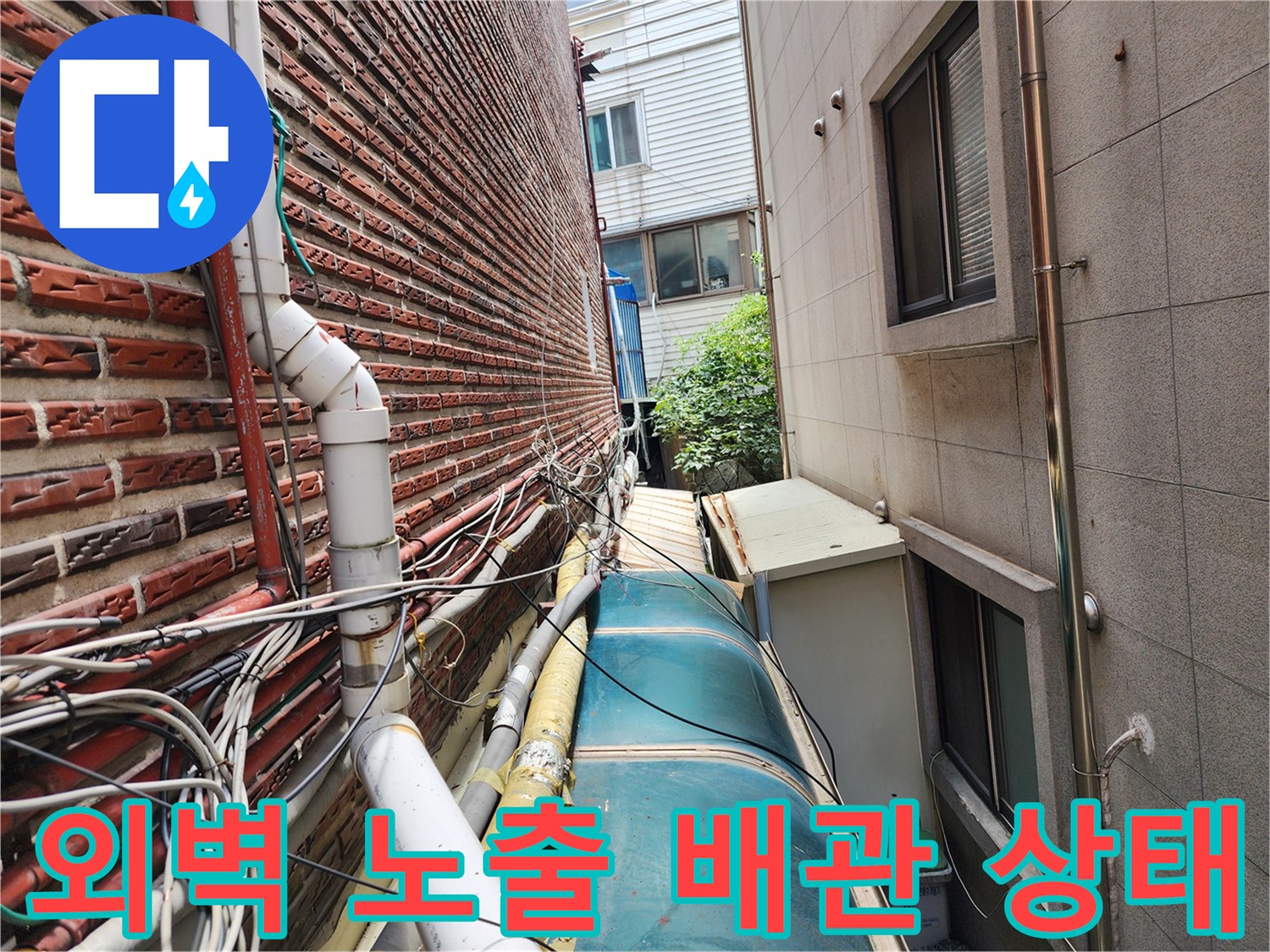 붉은 벽돌 외벽에 연결된 노출형 수도 및 온수 배관의 부식 상태