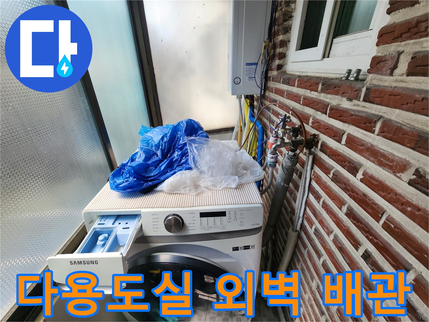 세탁기 뒤쪽 벽돌 외벽에 설치된 수도 계량기와 연결 배관들